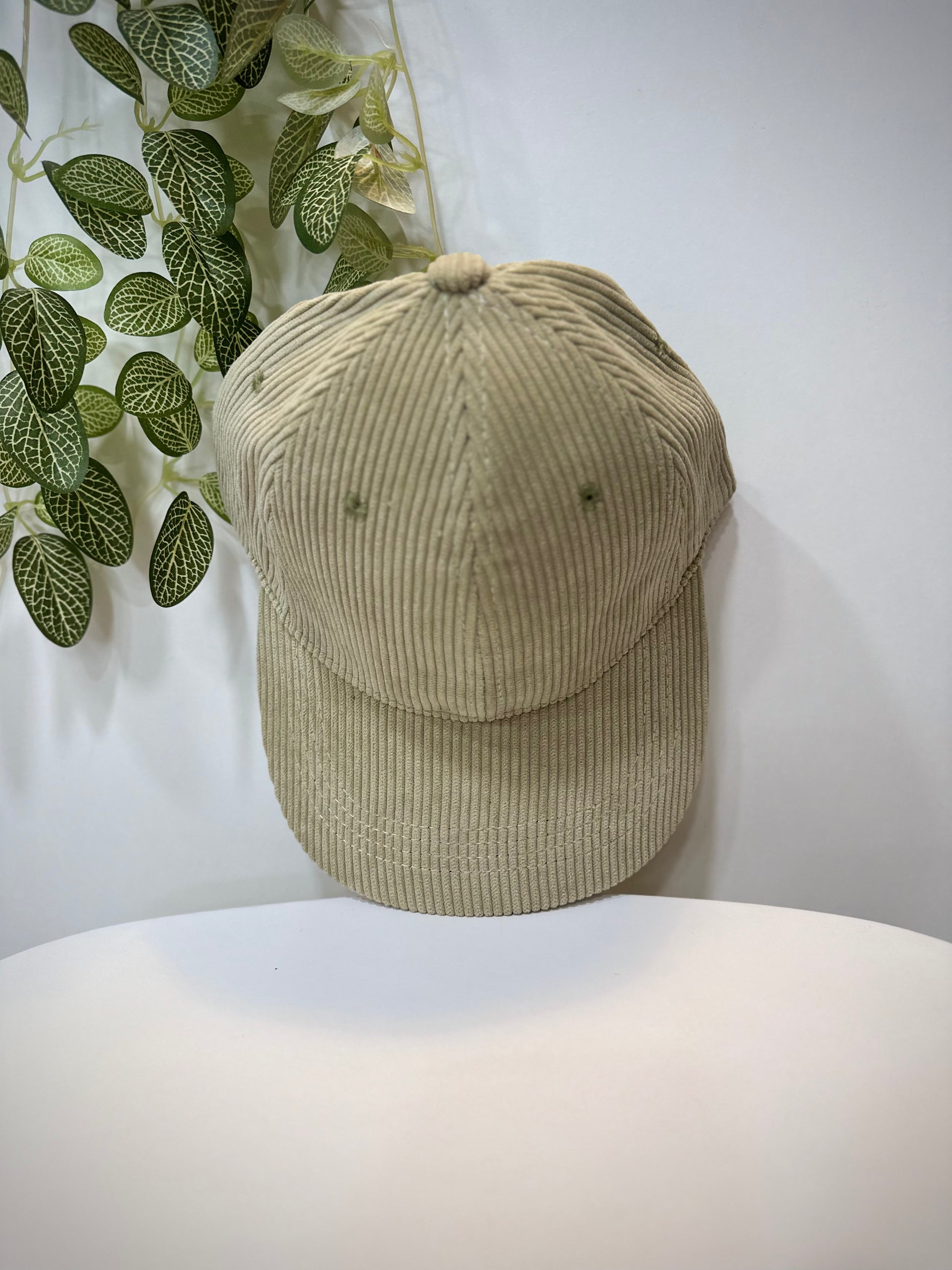 Casquette velours vert clair posée sur une table