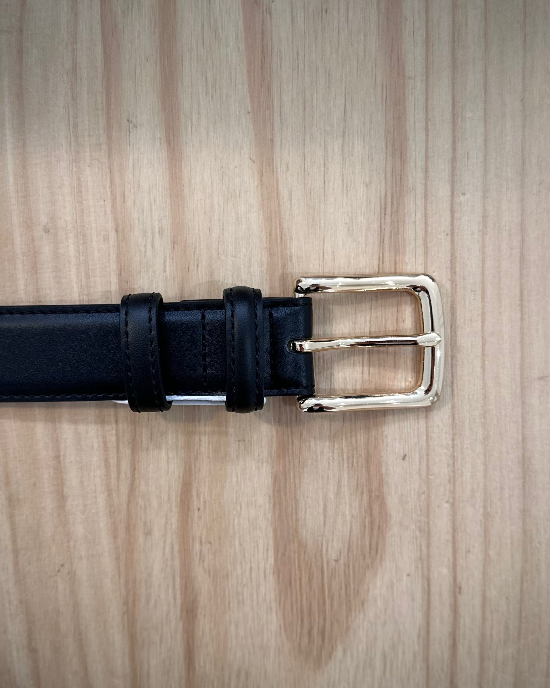 détail boucle dorée brillante sur ceinture femme noire