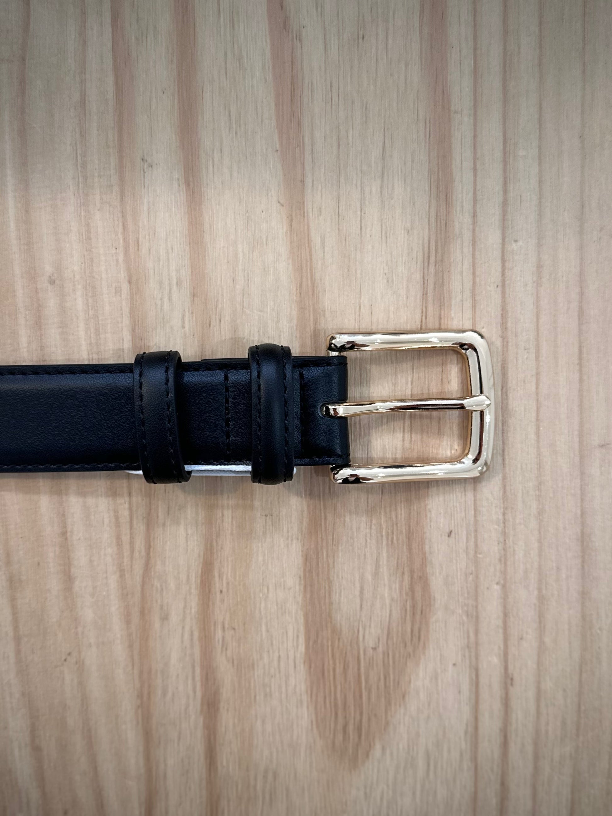 détail boucle dorée brillante sur ceinture femme noire