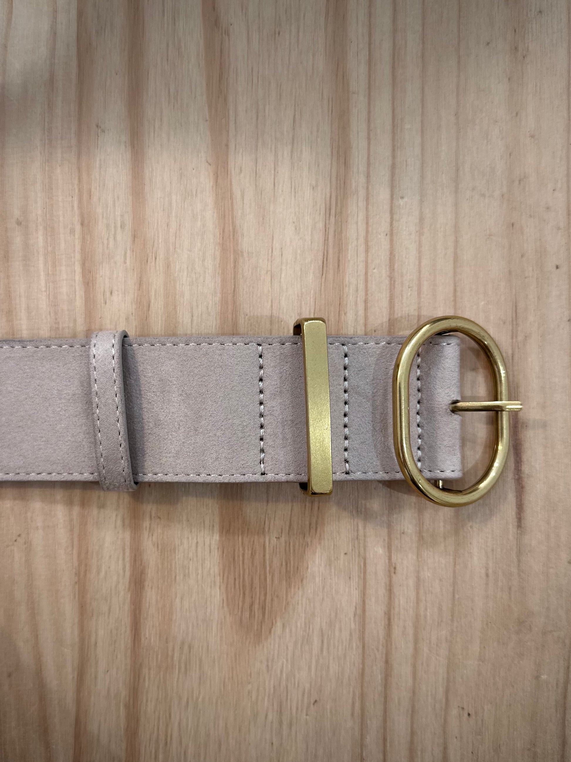 Détail boucle dorée brillante sur ceinture femme beige suédine