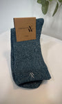 Paire de chaussettes bleu canard pliées sur fond neutre