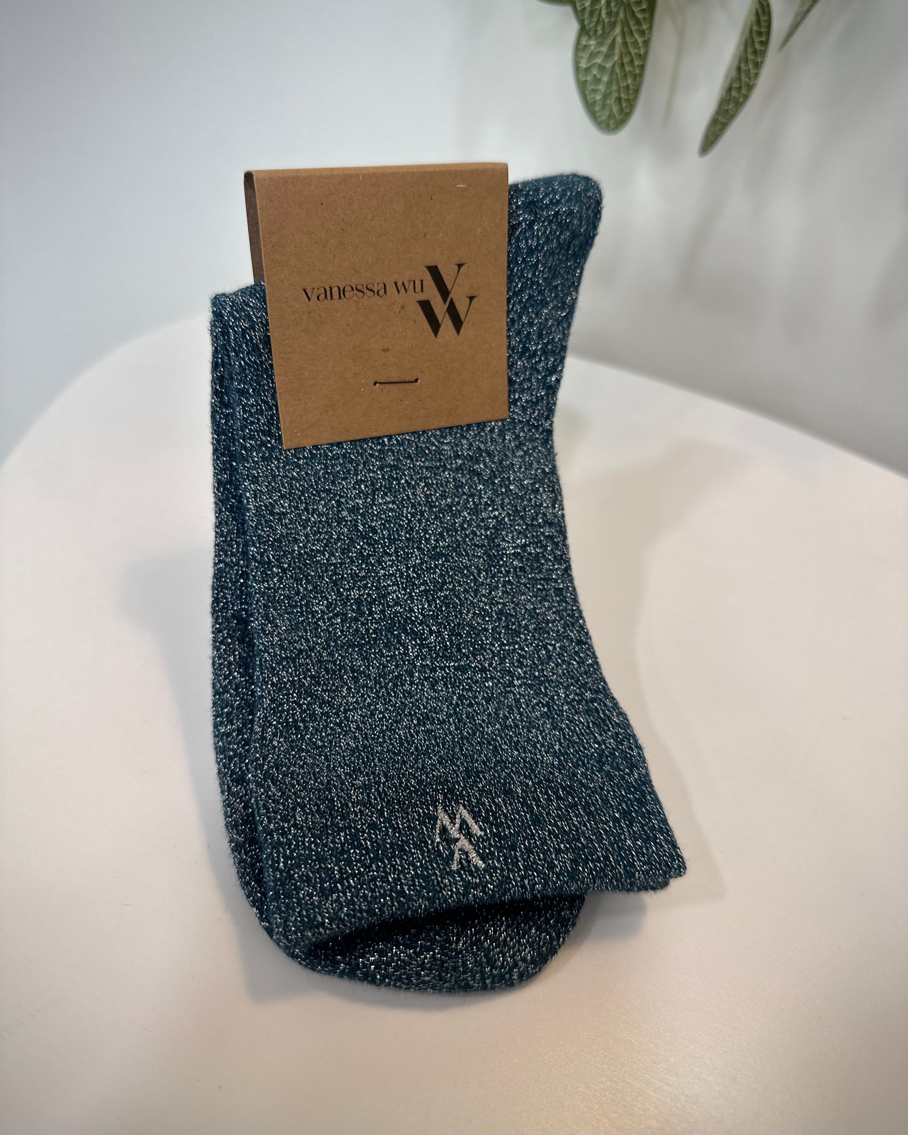 Paire de chaussettes bleu canard pliées sur fond neutre