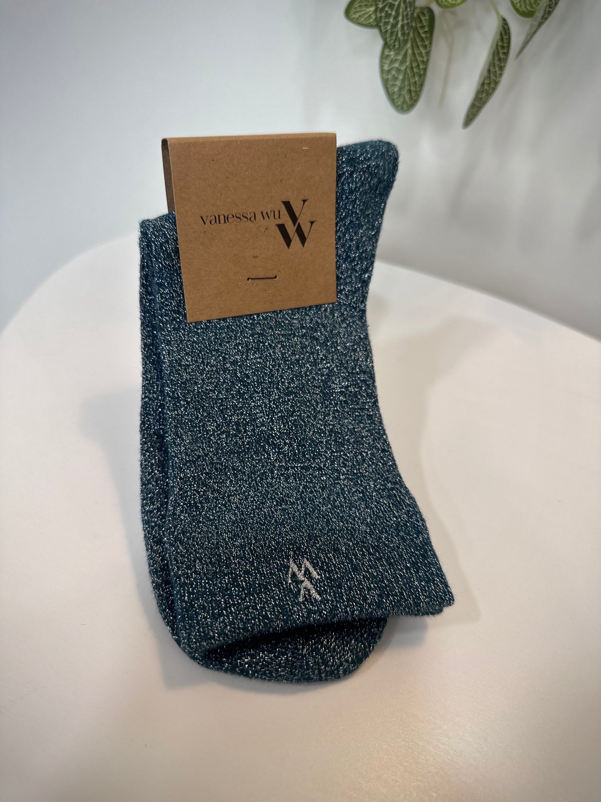 Paire de chaussettes bleu canard pliées sur fond neutre