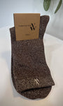 Paire de chaussettes marron scintillantes pliées sur fond neutre
