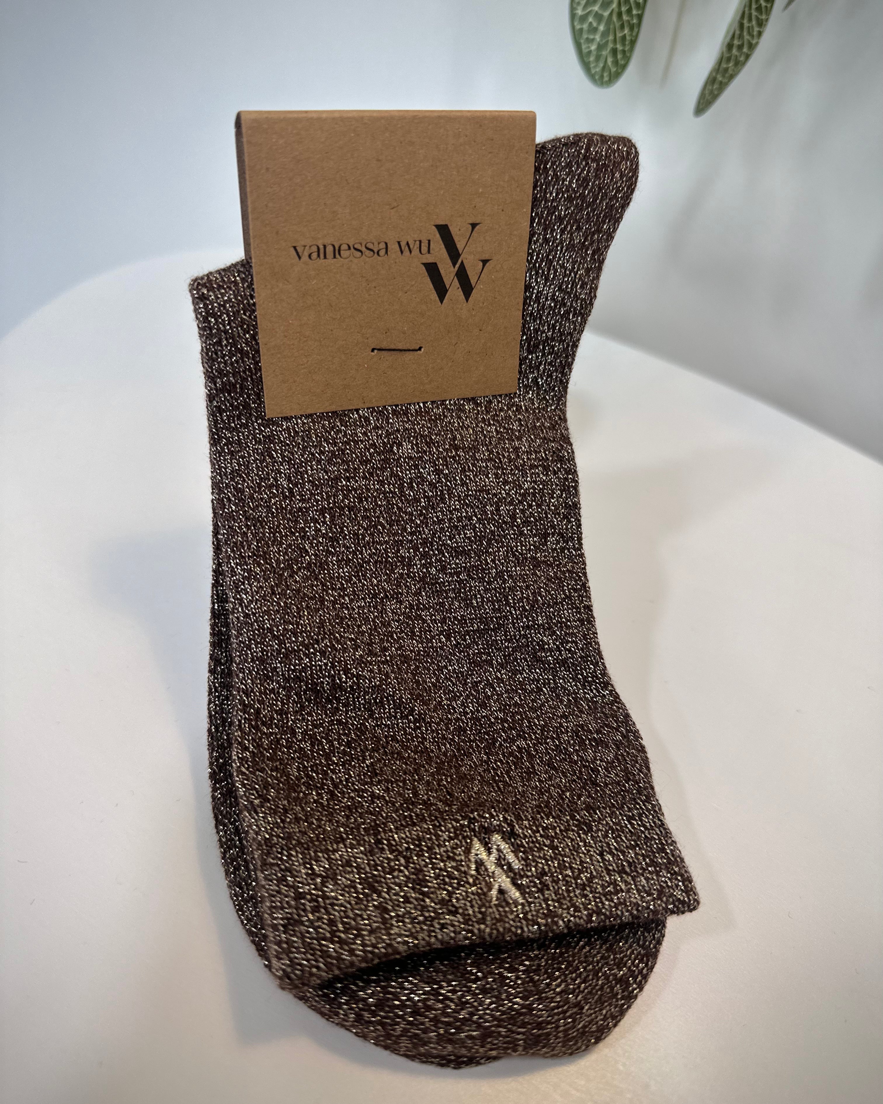 Paire de chaussettes marron scintillantes pliées sur fond neutre
