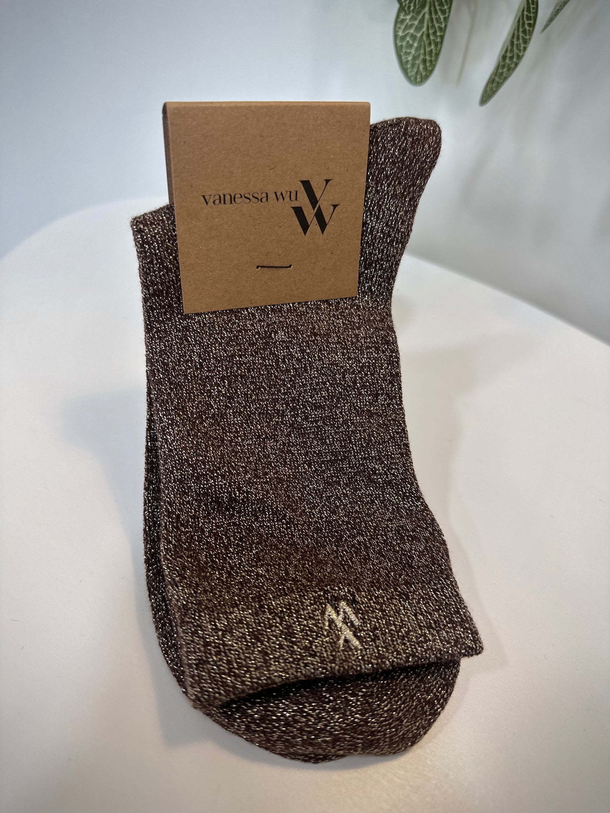 Paire de chaussettes marron scintillantes pliées sur fond neutre