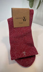 Paire de chaussettes rouges scintillantes pliées sur fond clair