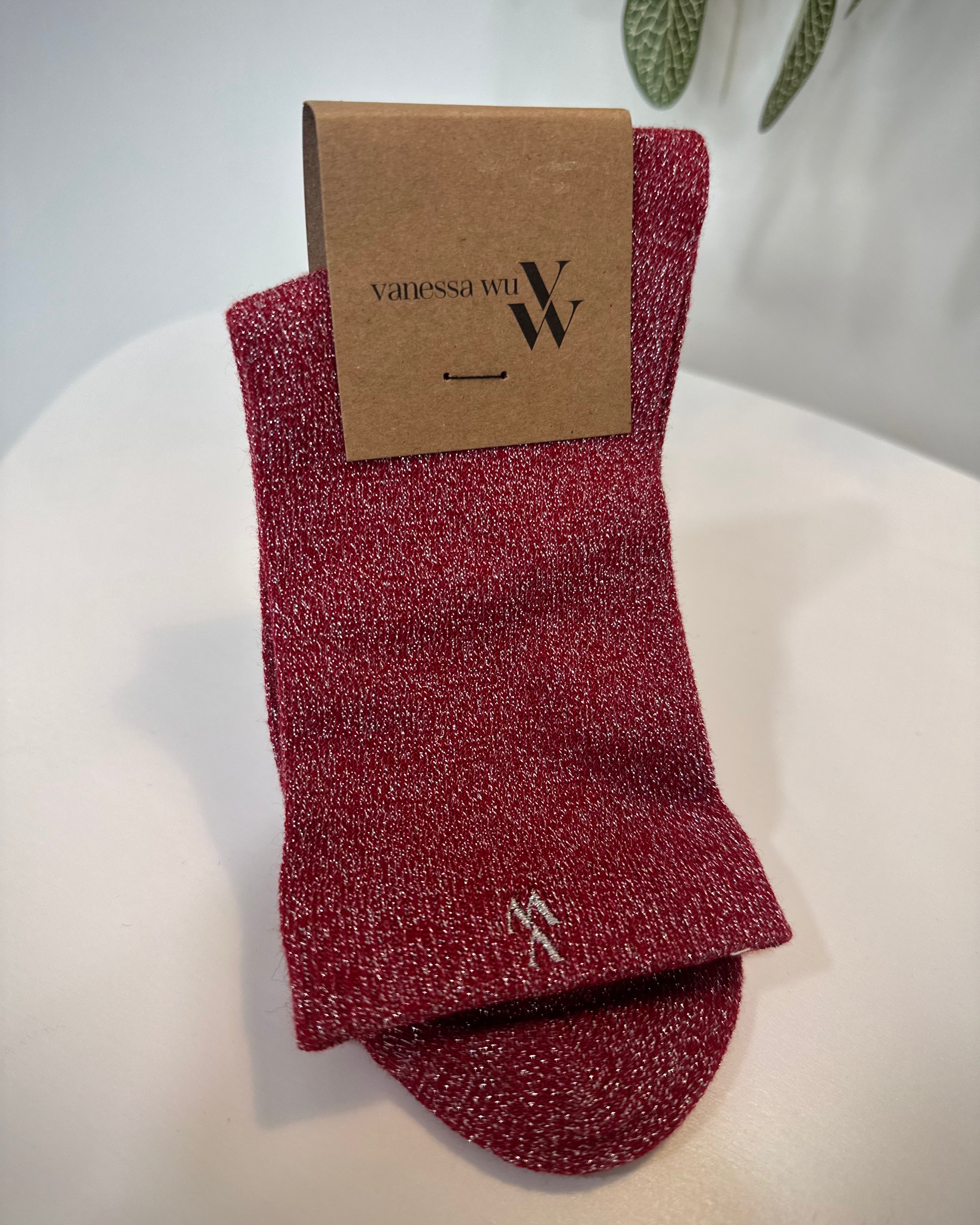 Paire de chaussettes rouges scintillantes pliées sur fond clair