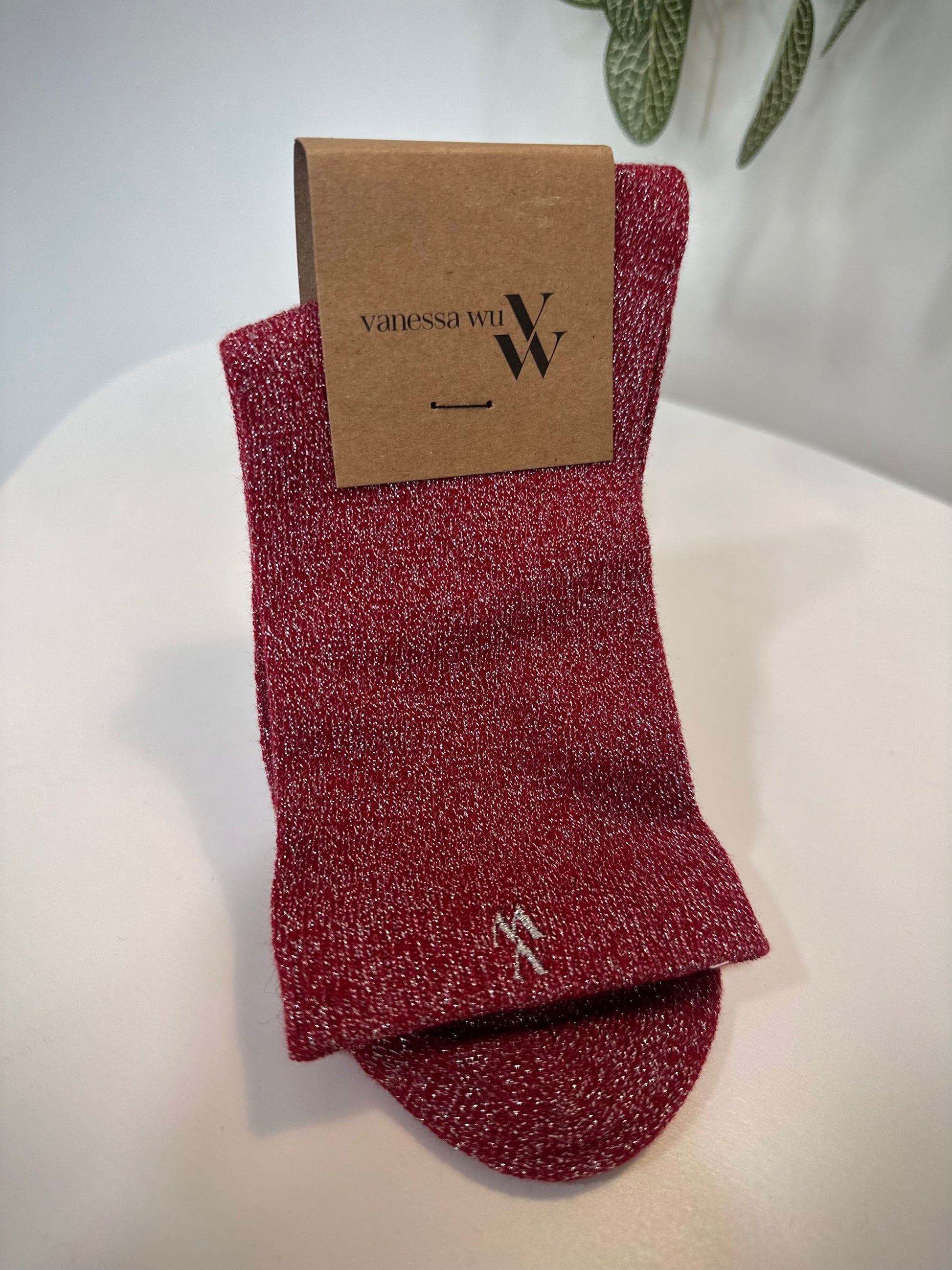 Paire de chaussettes rouges scintillantes pliées sur fond clair