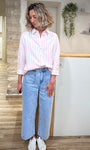 Femme portant chemise rayée rose avec un jean