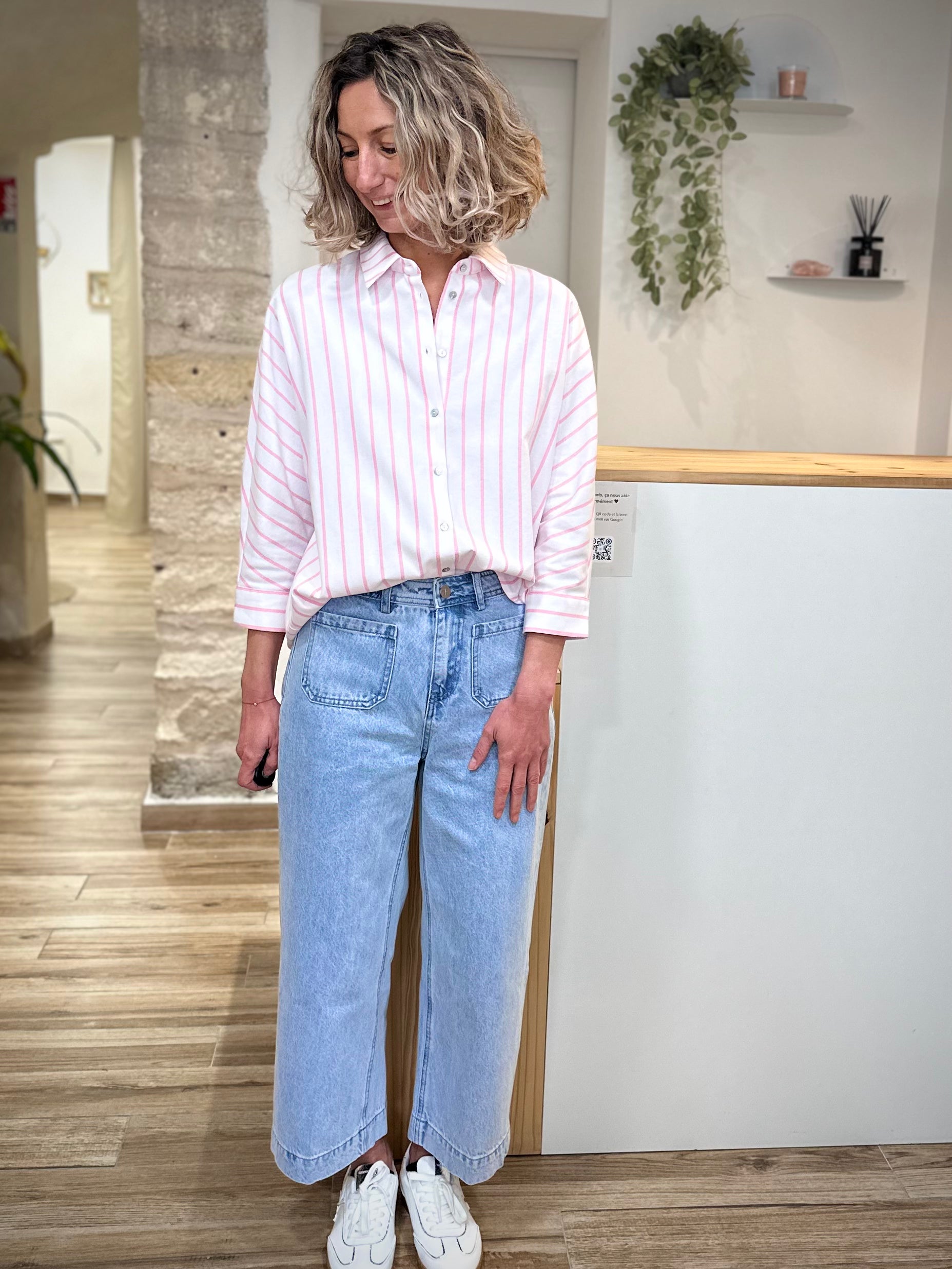 Femme portant chemise rayée rose avec un jean