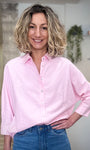Femme portant chemise rose pastel oversize 