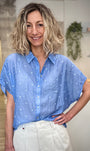 Femme portant une chemise bleue brodée à fleurs coupe ample 