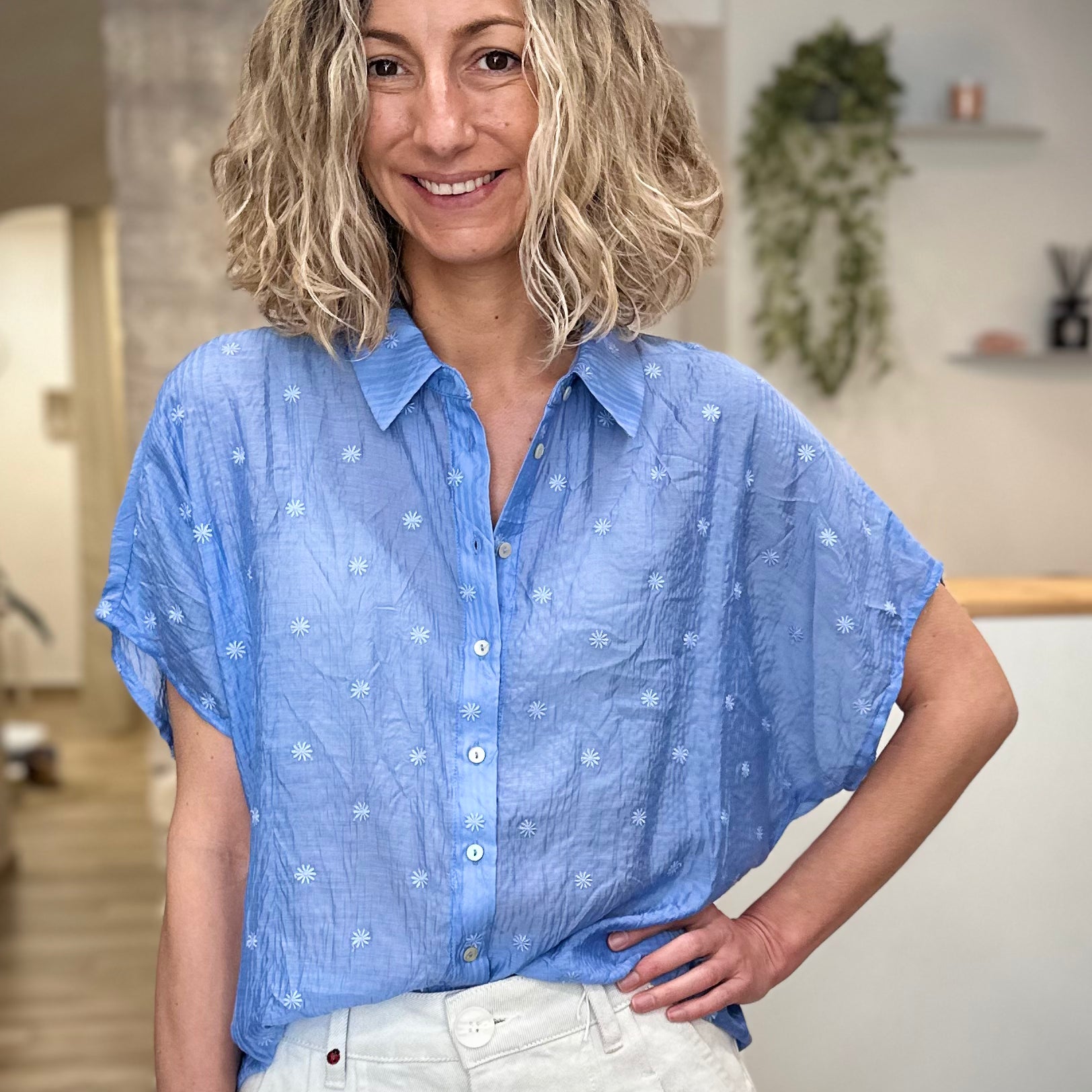 Femme portant une chemise bleue brodée à fleurs coupe ample 