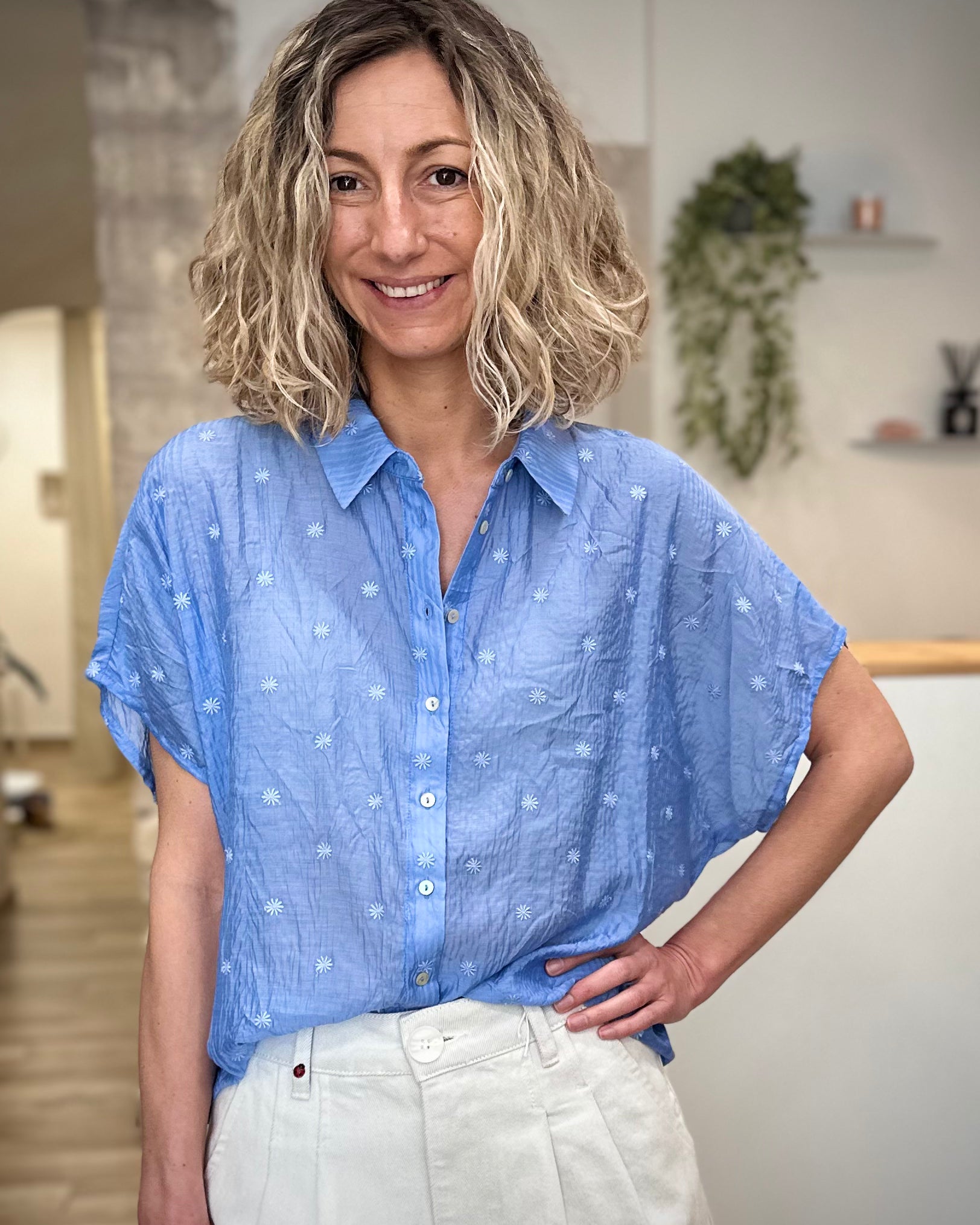 Femme portant une chemise bleue brodée à fleurs coupe ample 