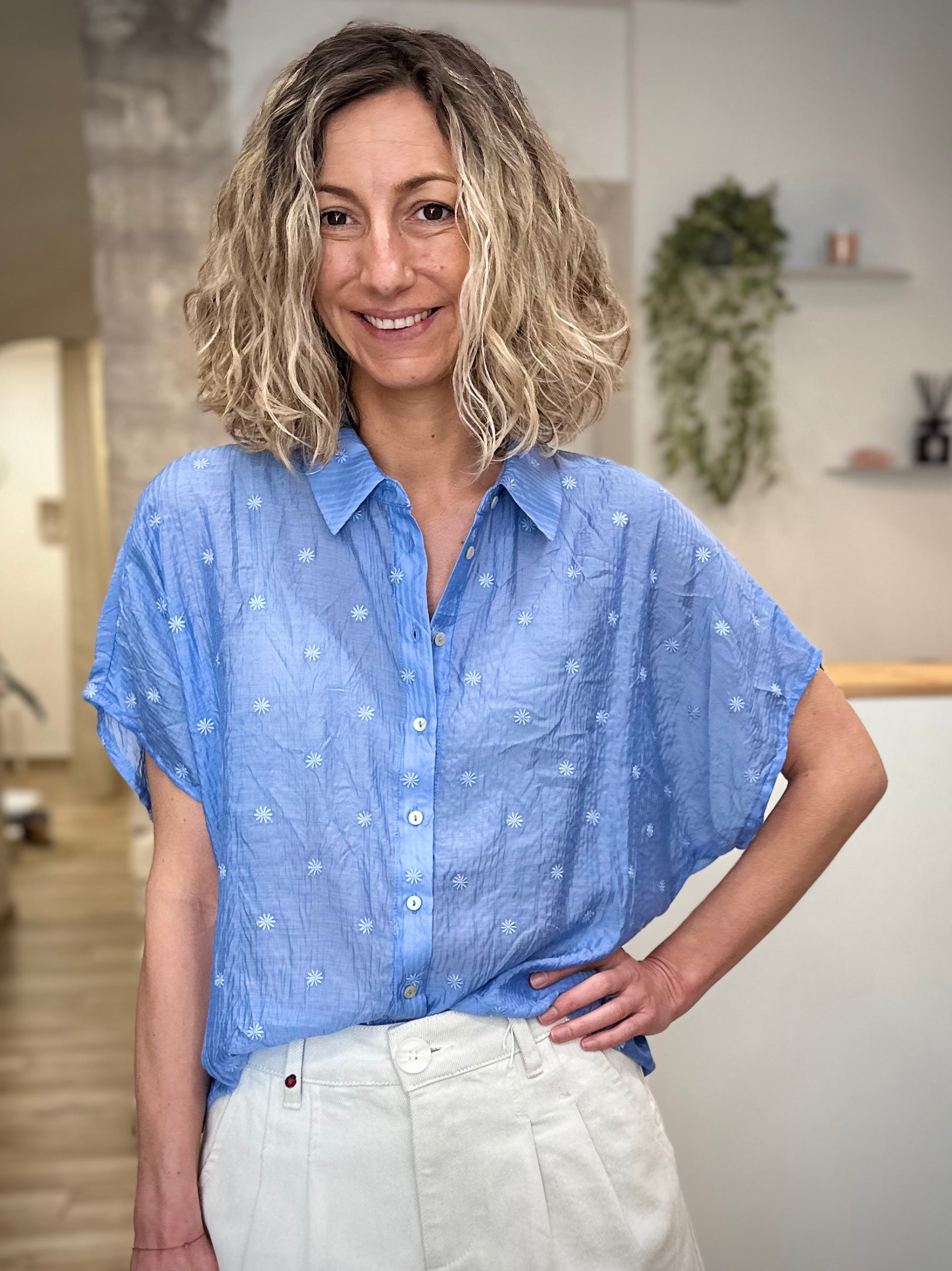 Femme portant une chemise bleue brodée à fleurs coupe ample 