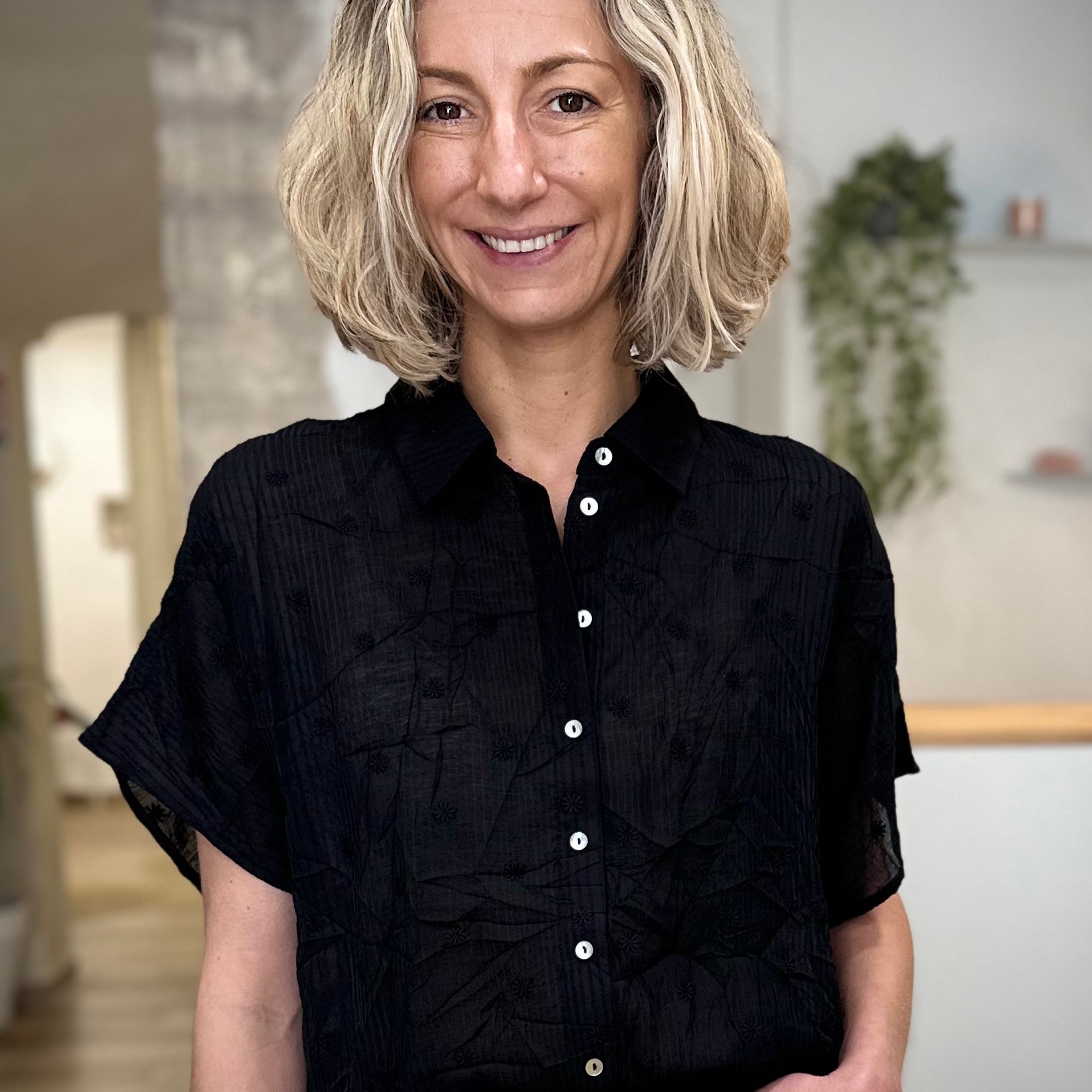 Femme portant une chemise noire à fleurs coupe fluide 