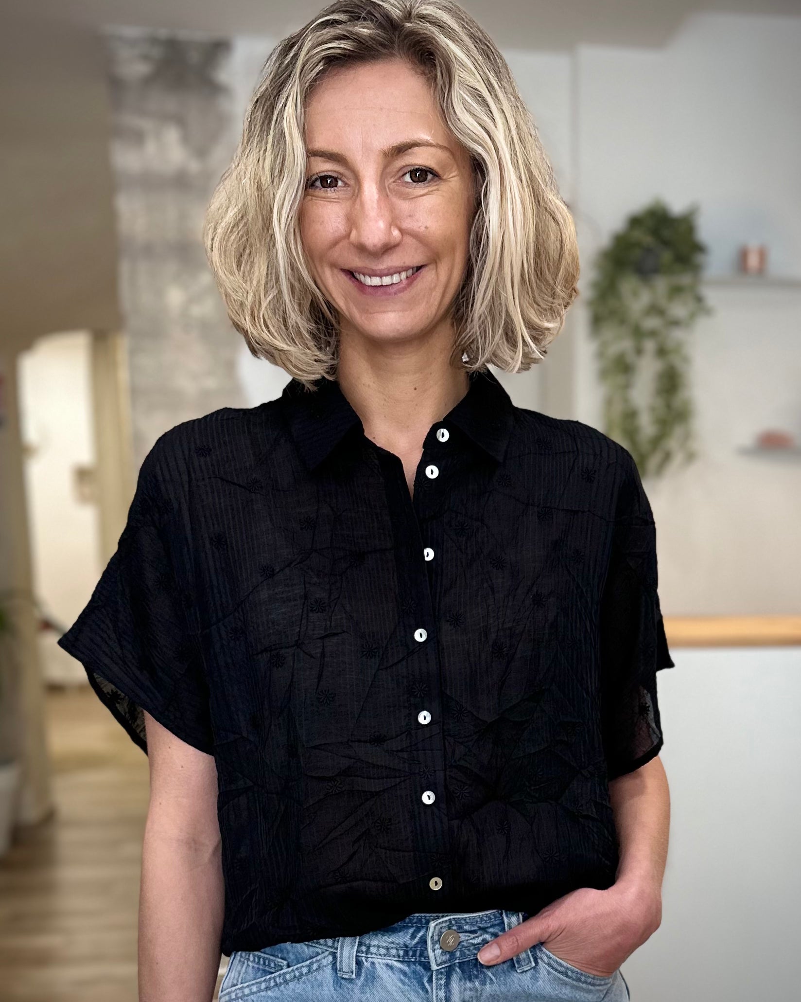 Femme portant une chemise noire à fleurs coupe fluide 