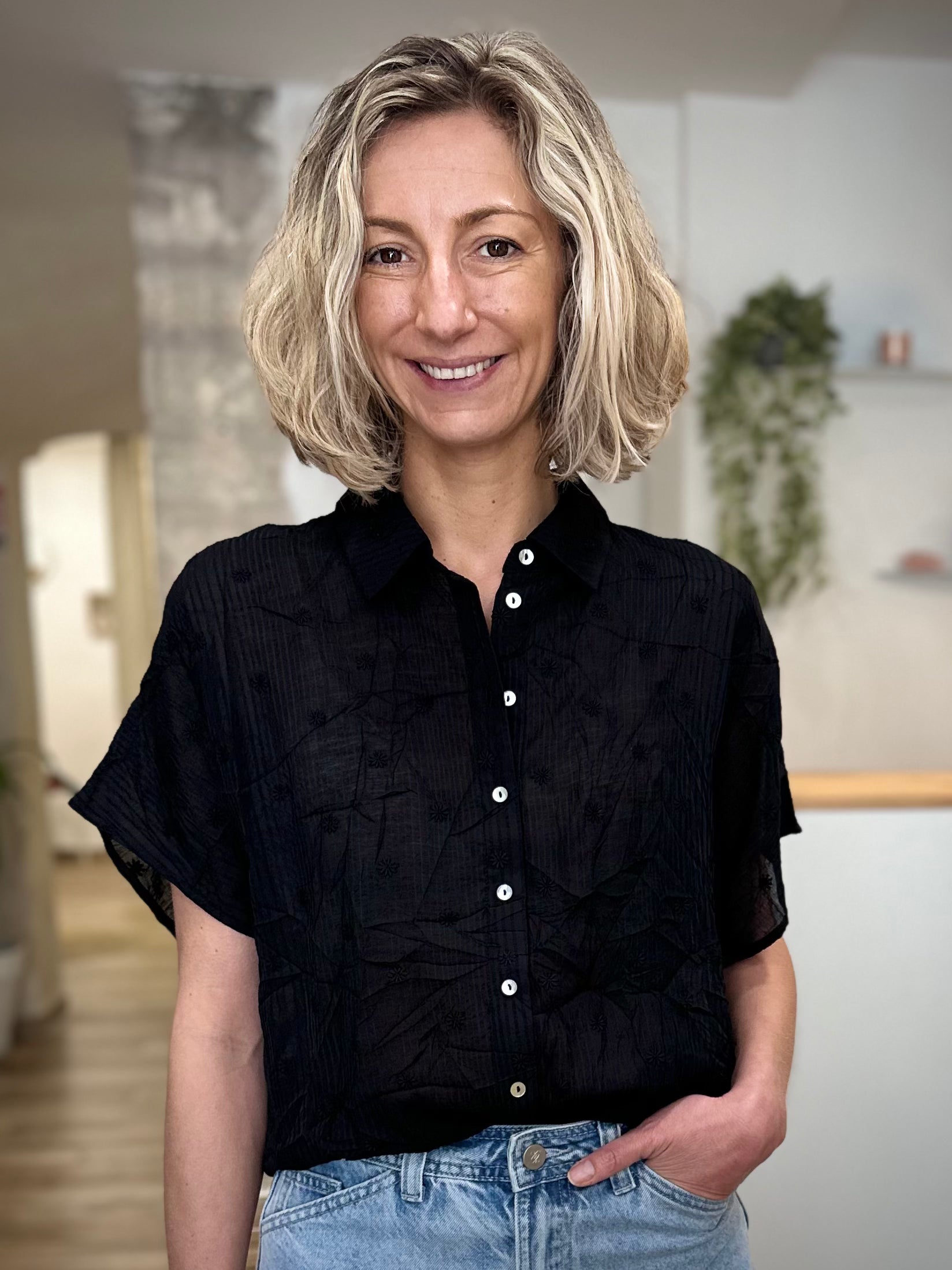Femme portant une chemise noire à fleurs coupe fluide 