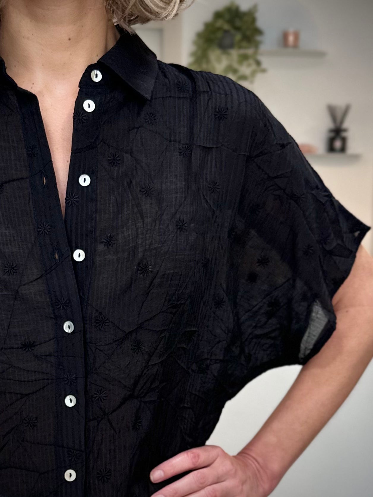 Détail broderies fleurs sur chemise noire femme 