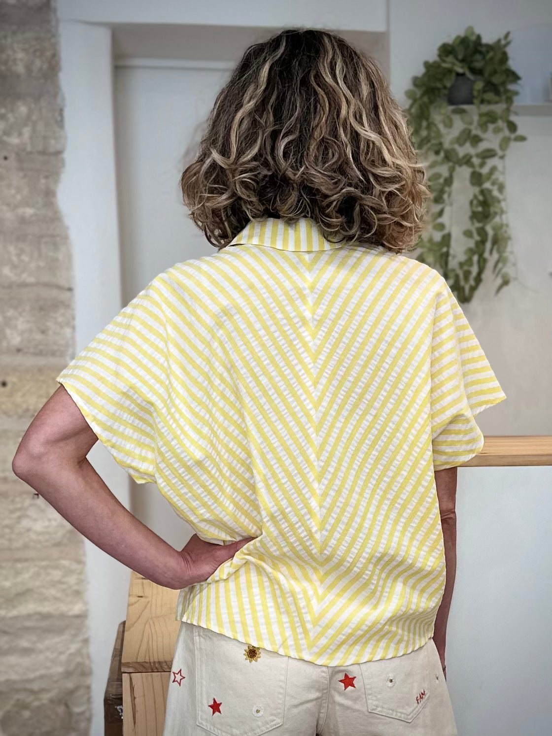 Femme de dos en blouse rayée jaune et blanc tendance 