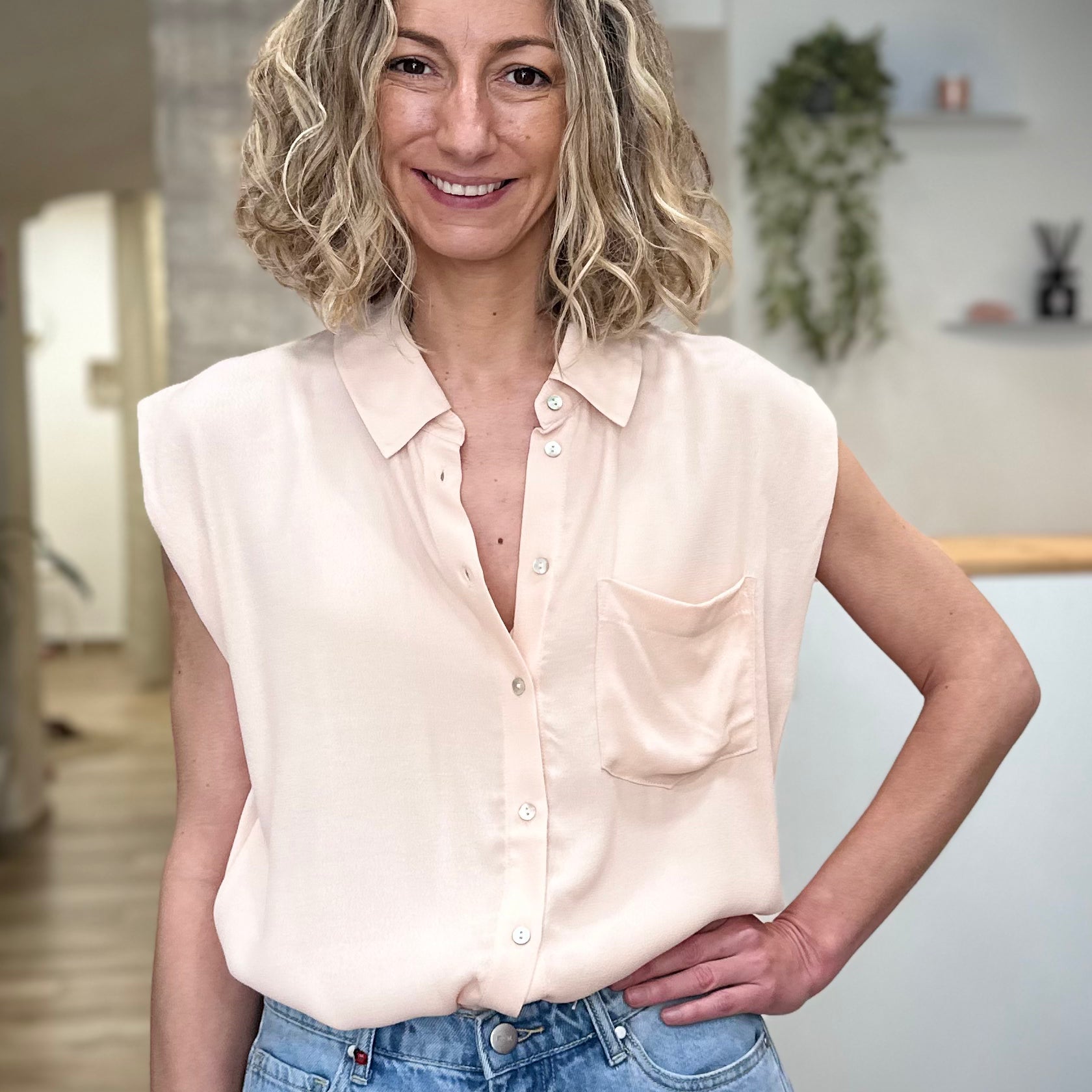 Femme portant chemise fluide beige sans manches été 
