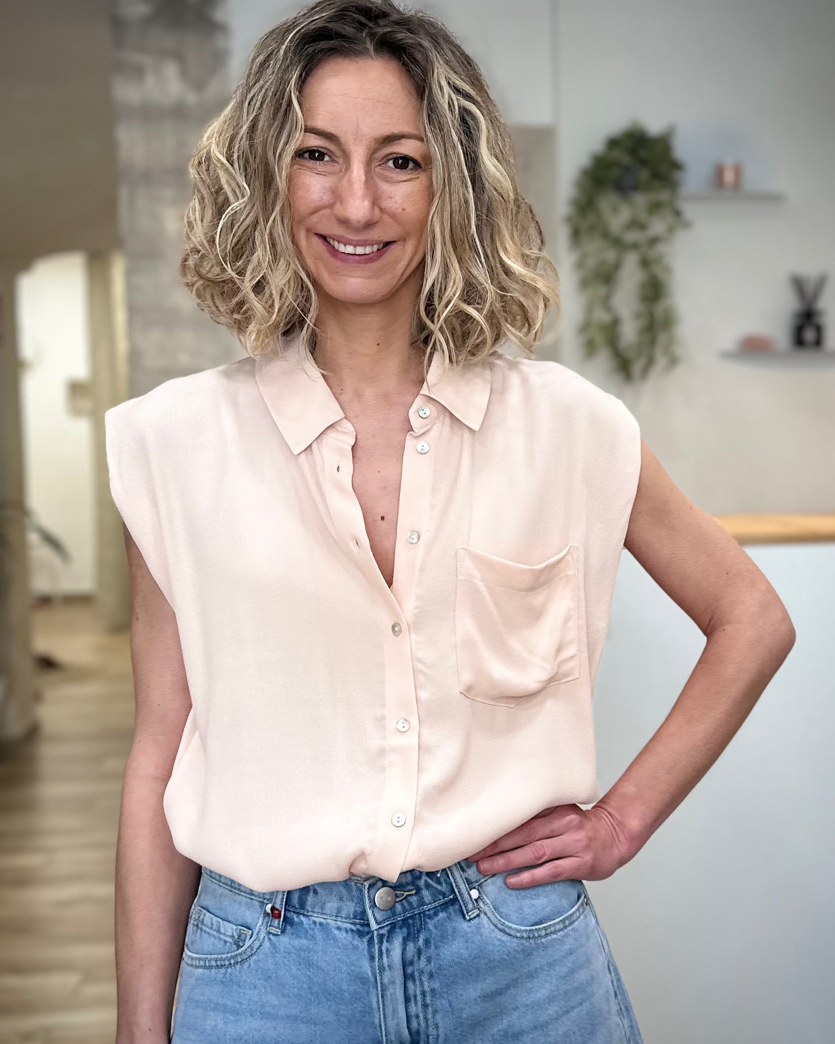 Femme portant chemise fluide beige sans manches été 