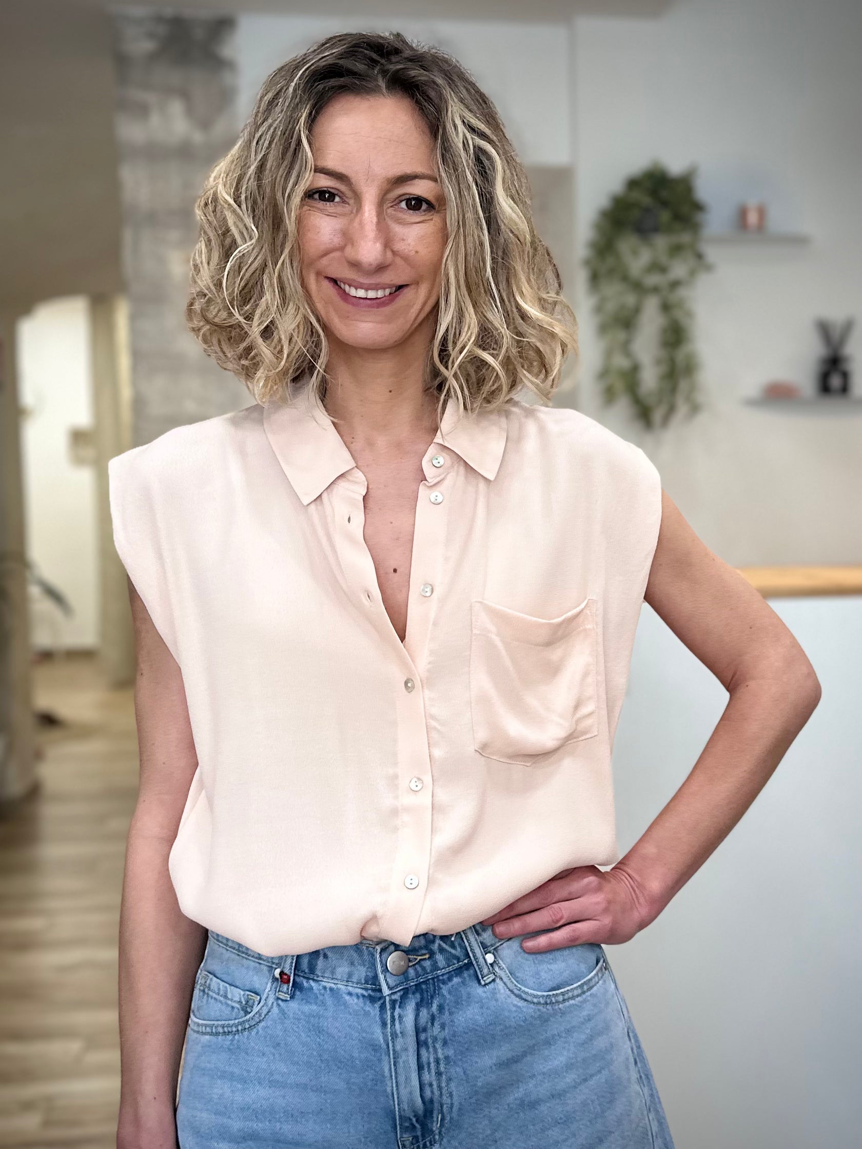 Femme portant chemise fluide beige sans manches été 