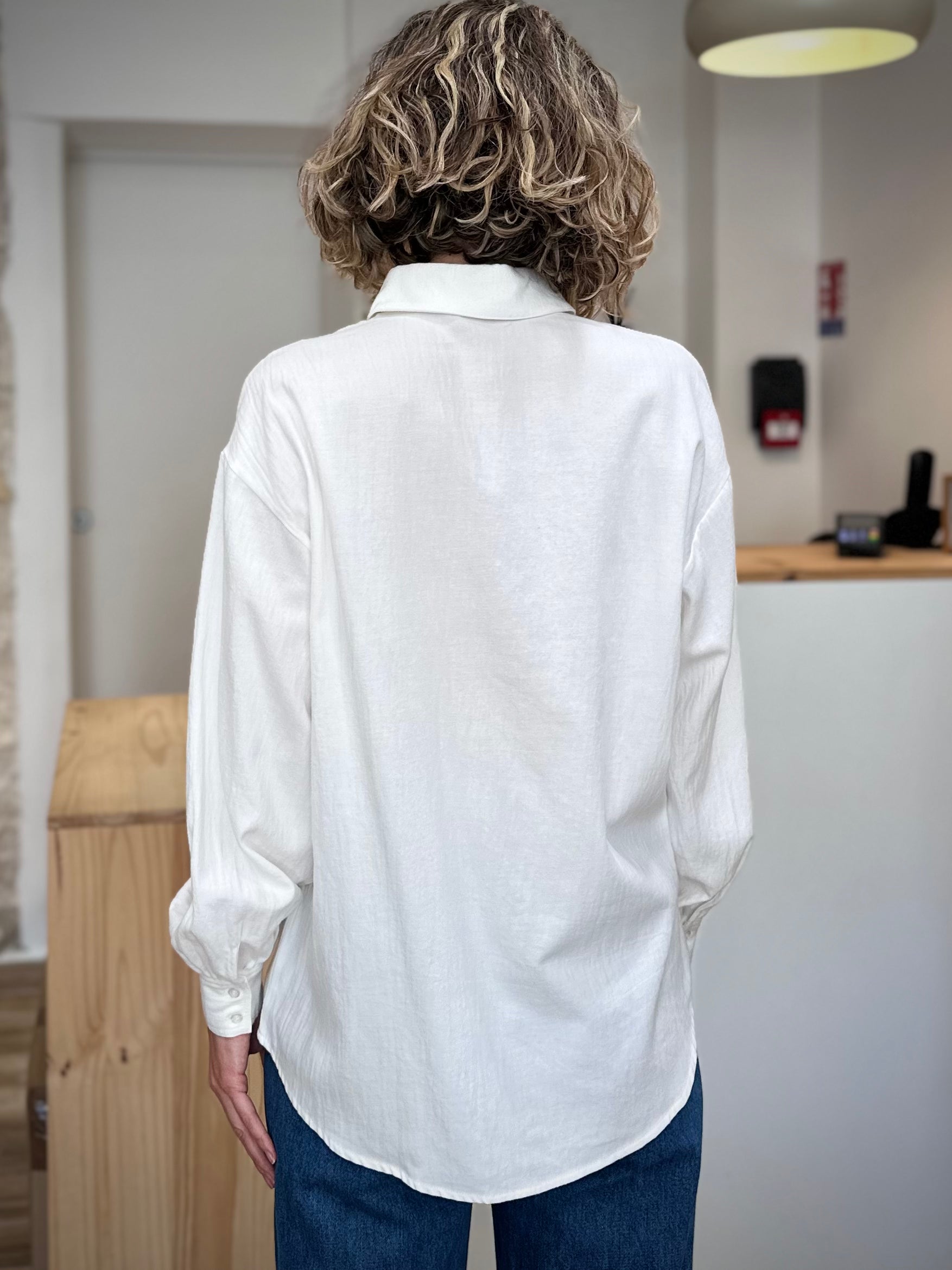 Vue de dos de la chemise blanche manches longues et épaules tombantes