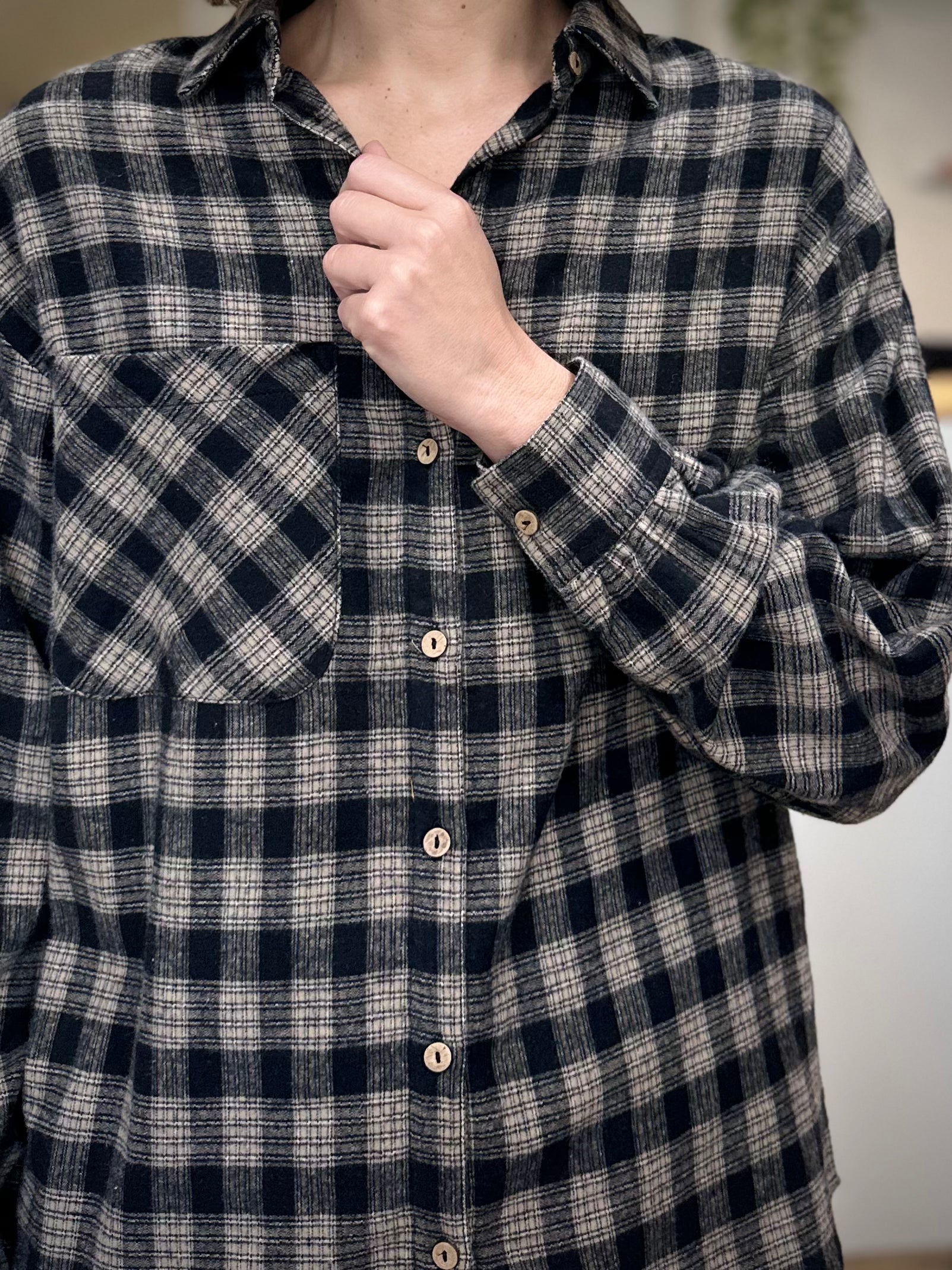 Gros plan sur les finitions d’une chemise à carreaux