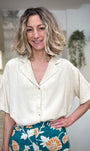 Femme portant une chemise beige fluide coupe ample été 
