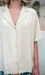 Détail chemise beige boutons devant tissu fluide 