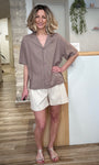 Femme souriante portant chemise mocha et short clair 