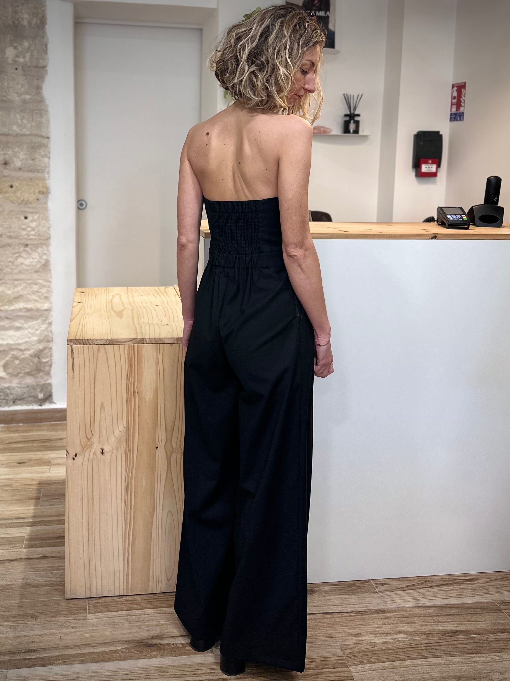 Vue de dos combinaison noire jambes évasées