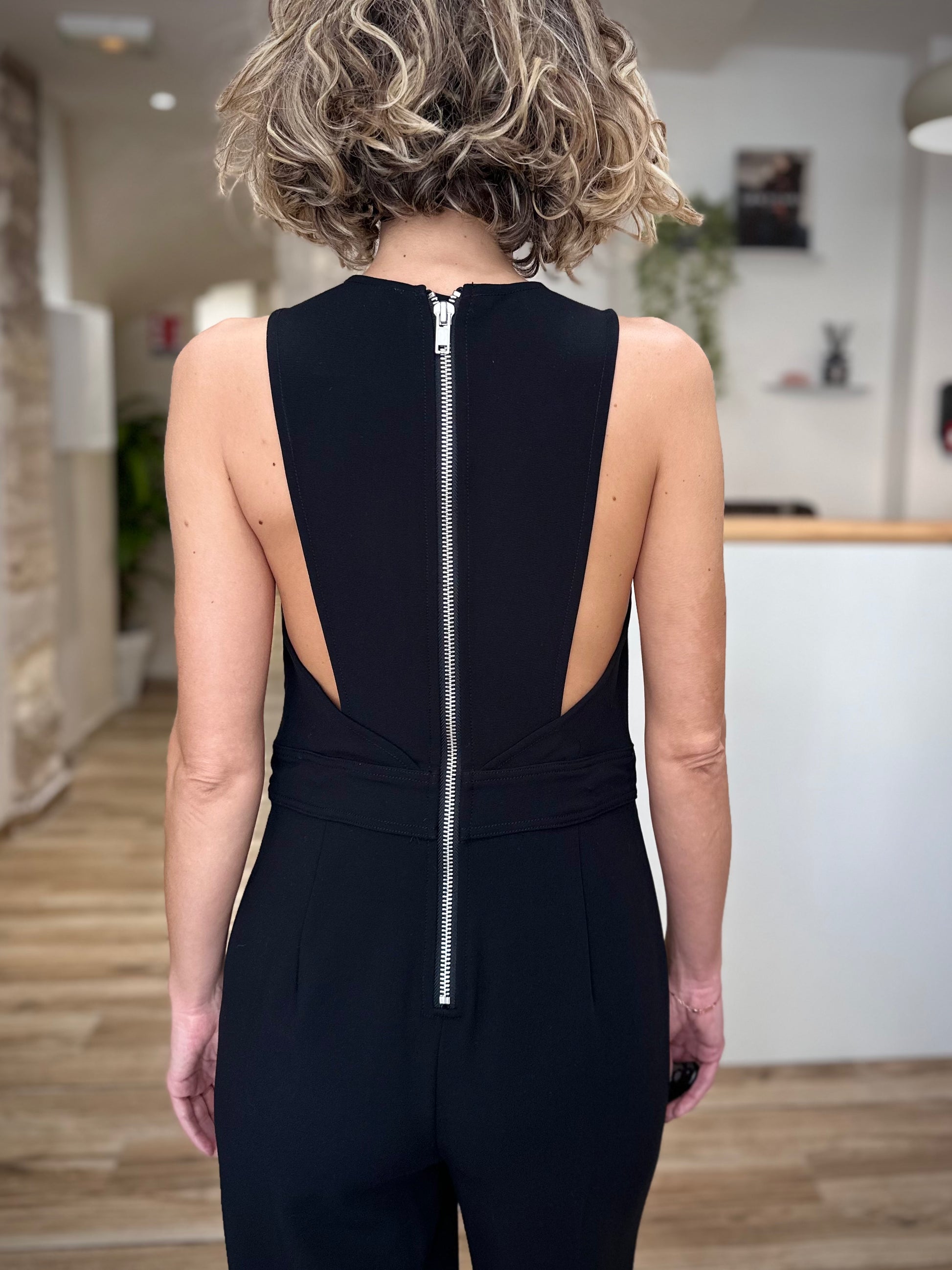 Détail du zip argenté visible sur la combinaison noire