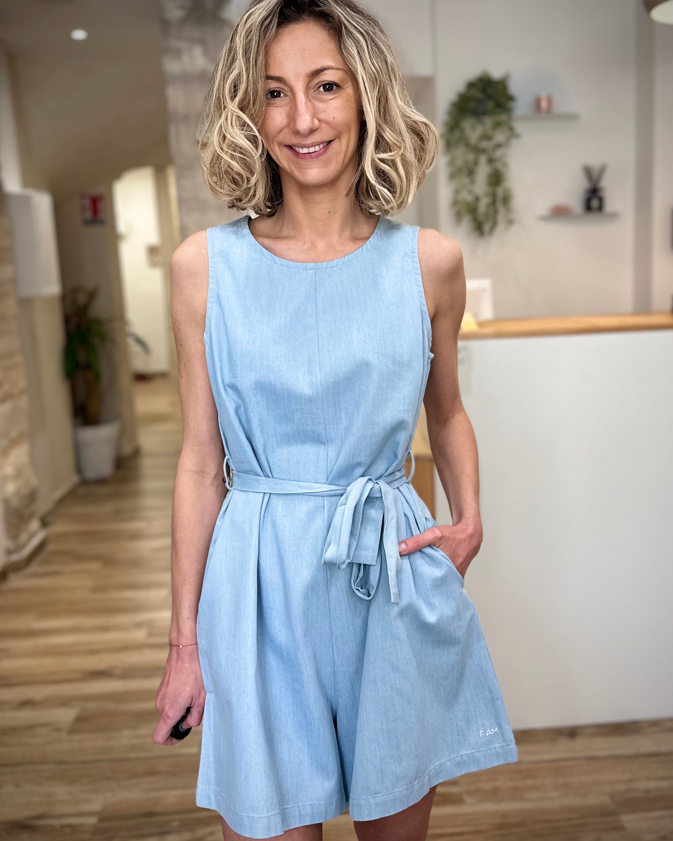 Femme portant combinaison short bleu clair en coton coupe fluide 