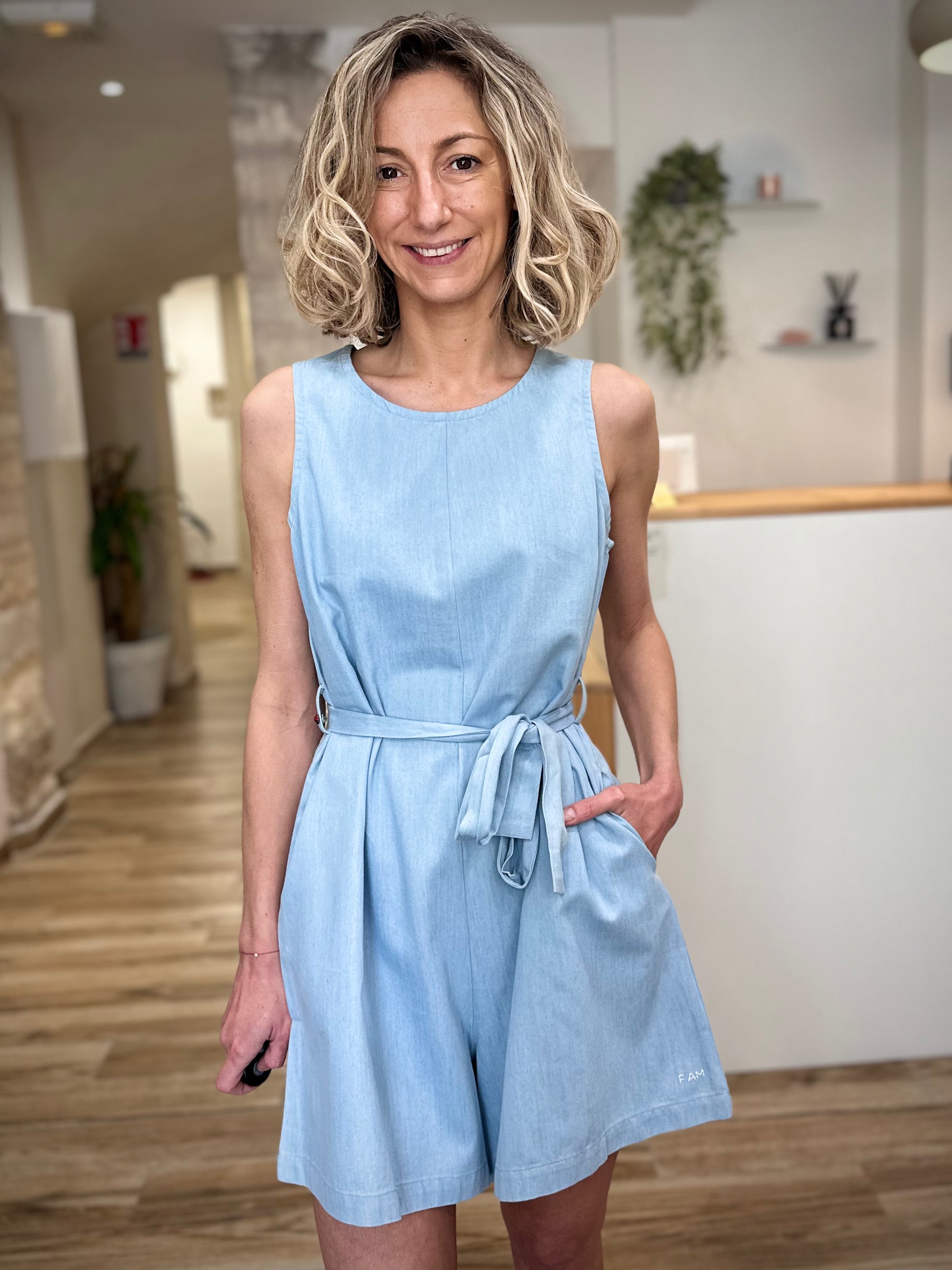 Femme portant combinaison short bleu clair en coton coupe fluide 