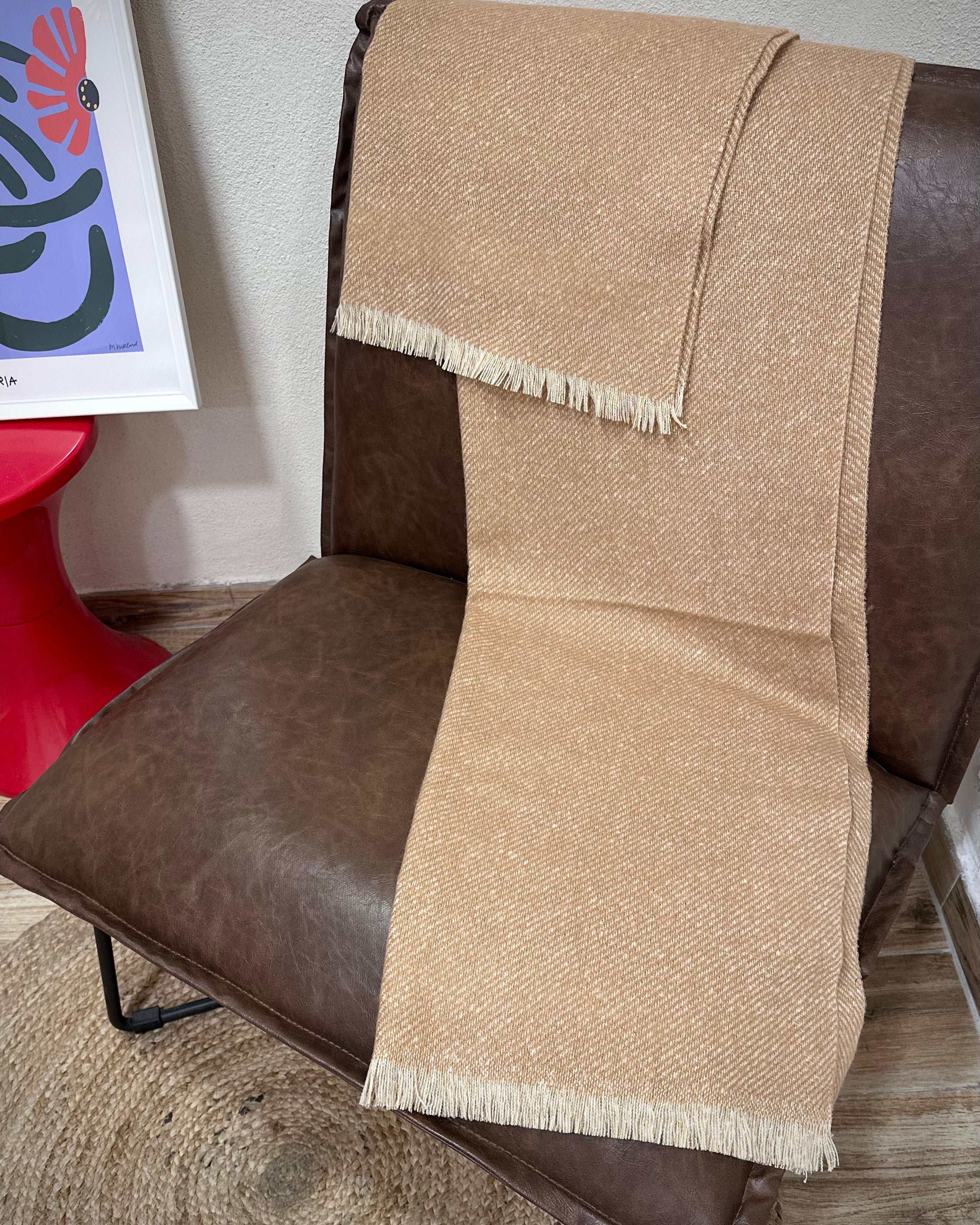 écharpe Mira beige doré posée sur un fauteuil