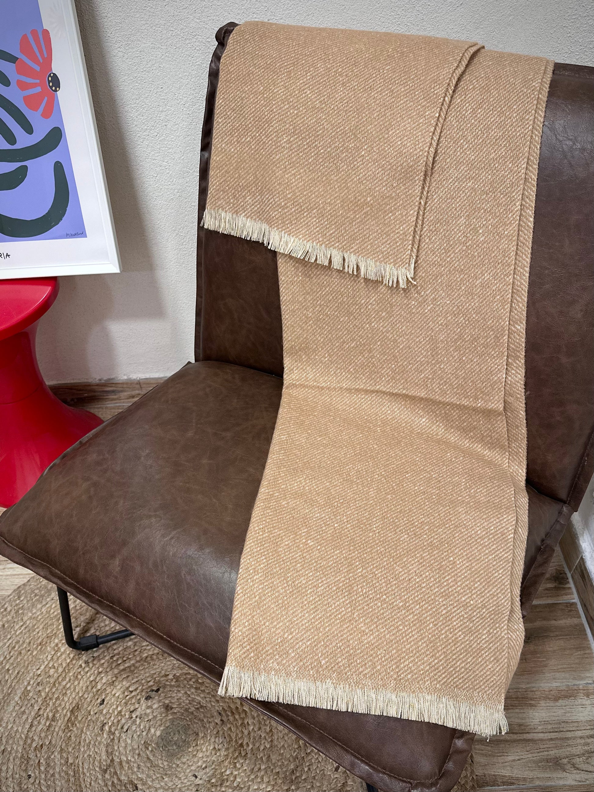 écharpe Mira beige doré posée sur un fauteuil