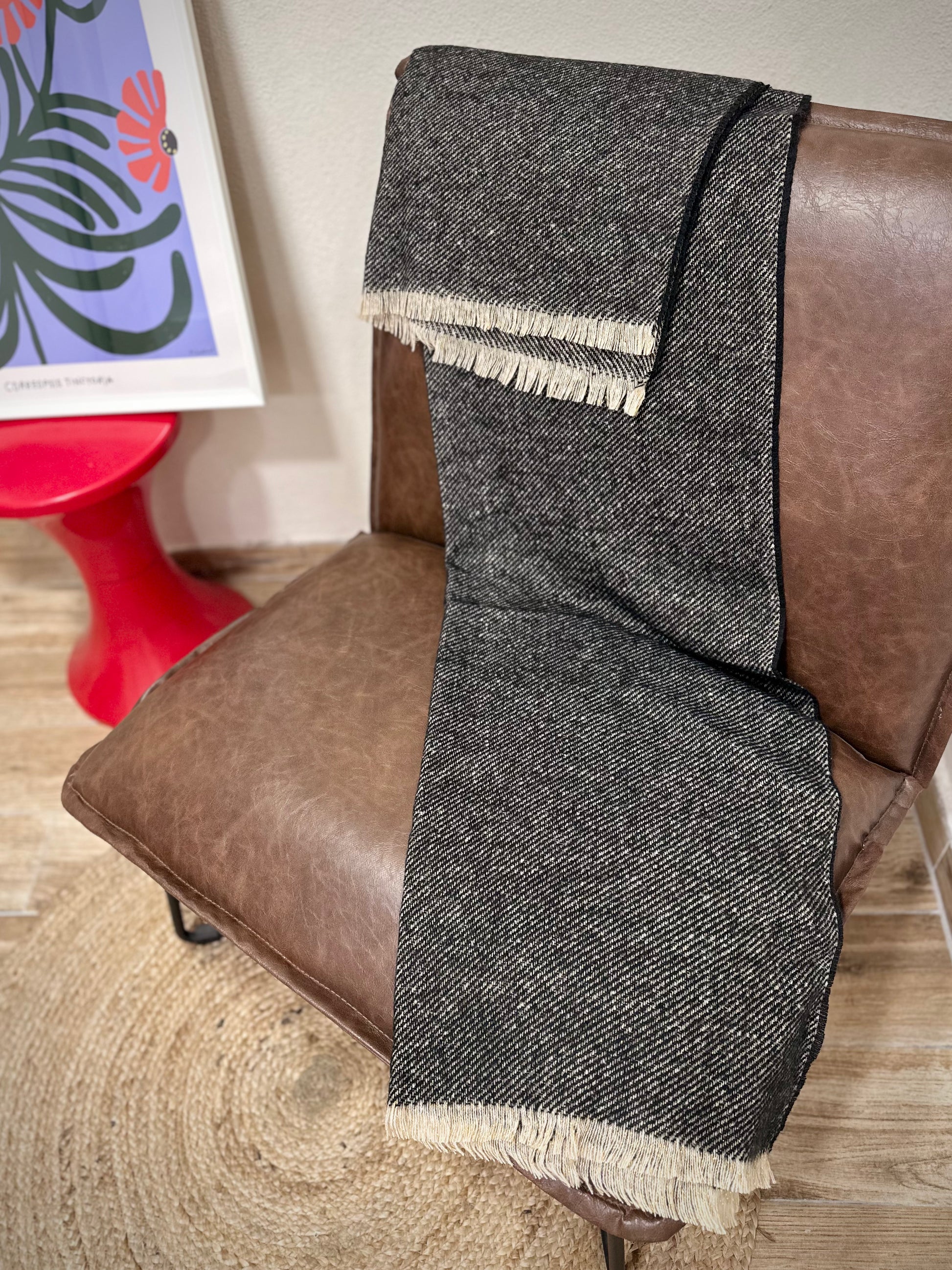 écharpe Mira noire dorée posée sur un fauteuil