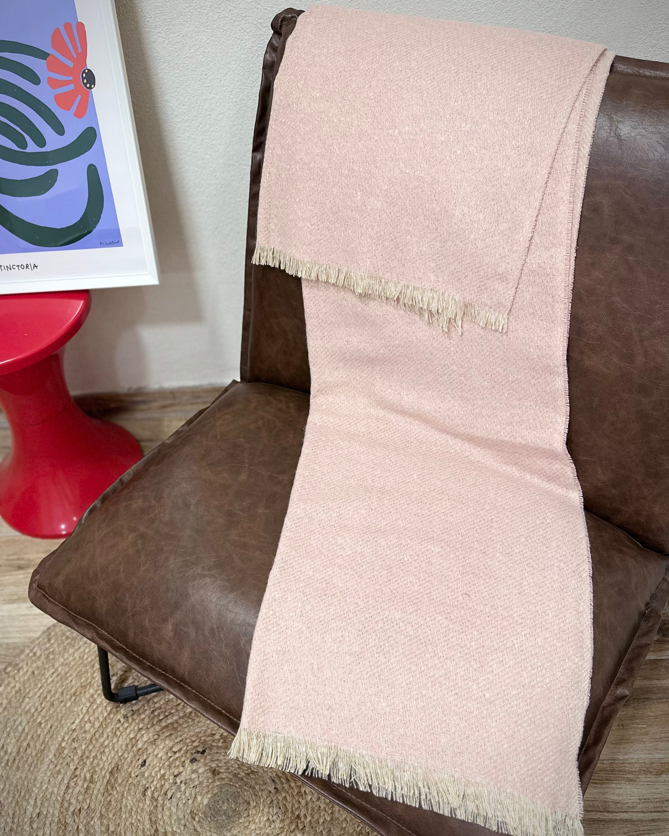 écharpe Mira rose pastel doré posée sur un fauteuil