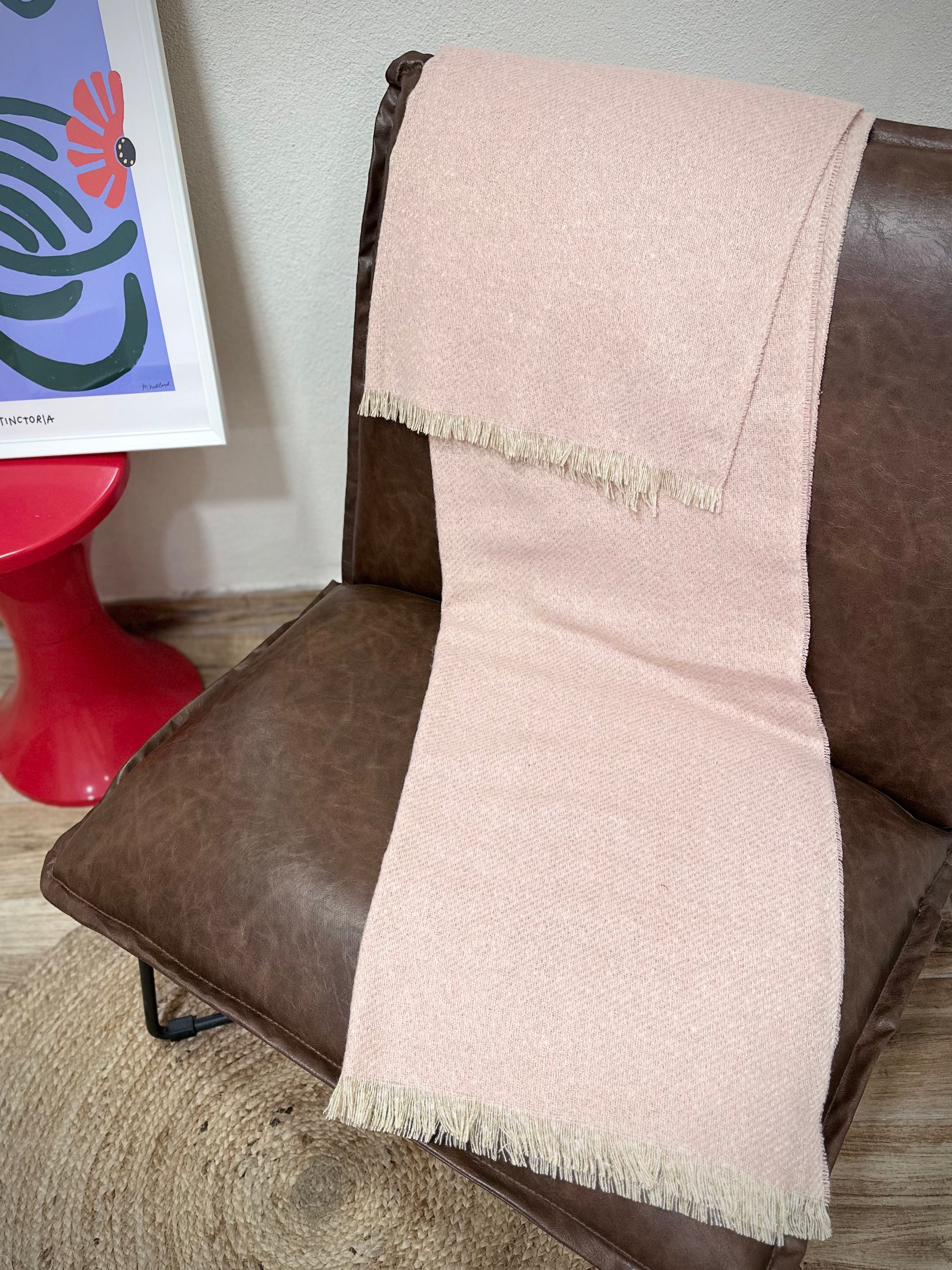 écharpe Mira rose pastel doré posée sur un fauteuil