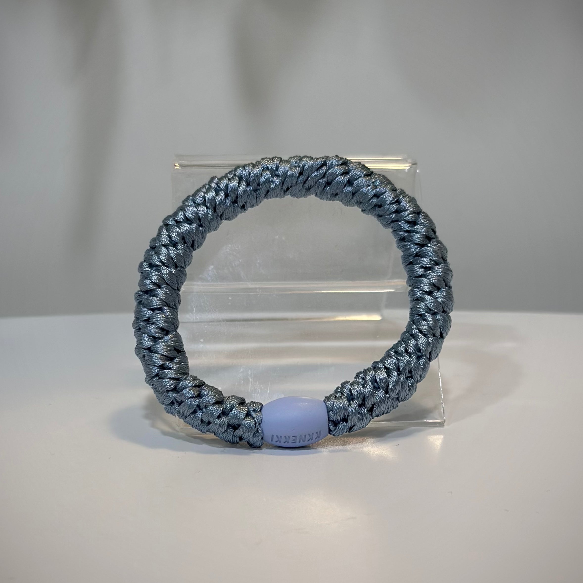 élastiques Kknekki bleu ciel posés sur une table en bois clair