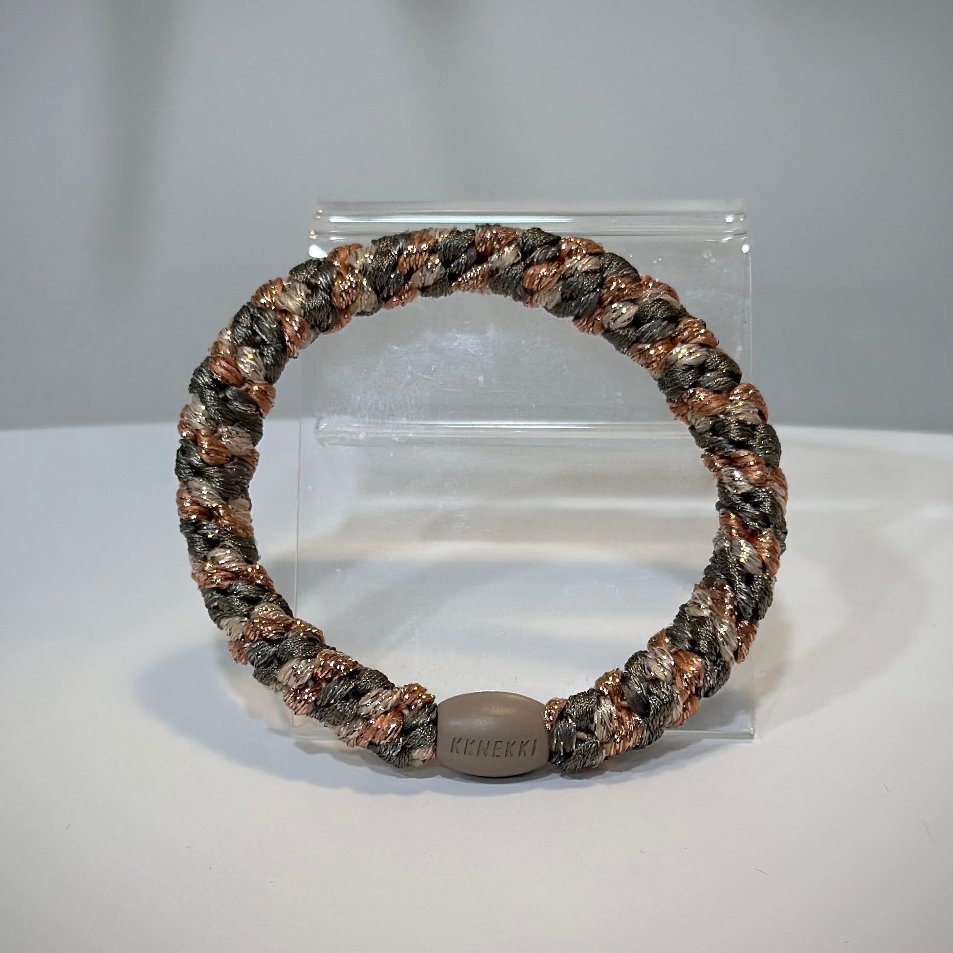 élastiques cheveux Kknekki kaki rose gold posés sur table en bois clair