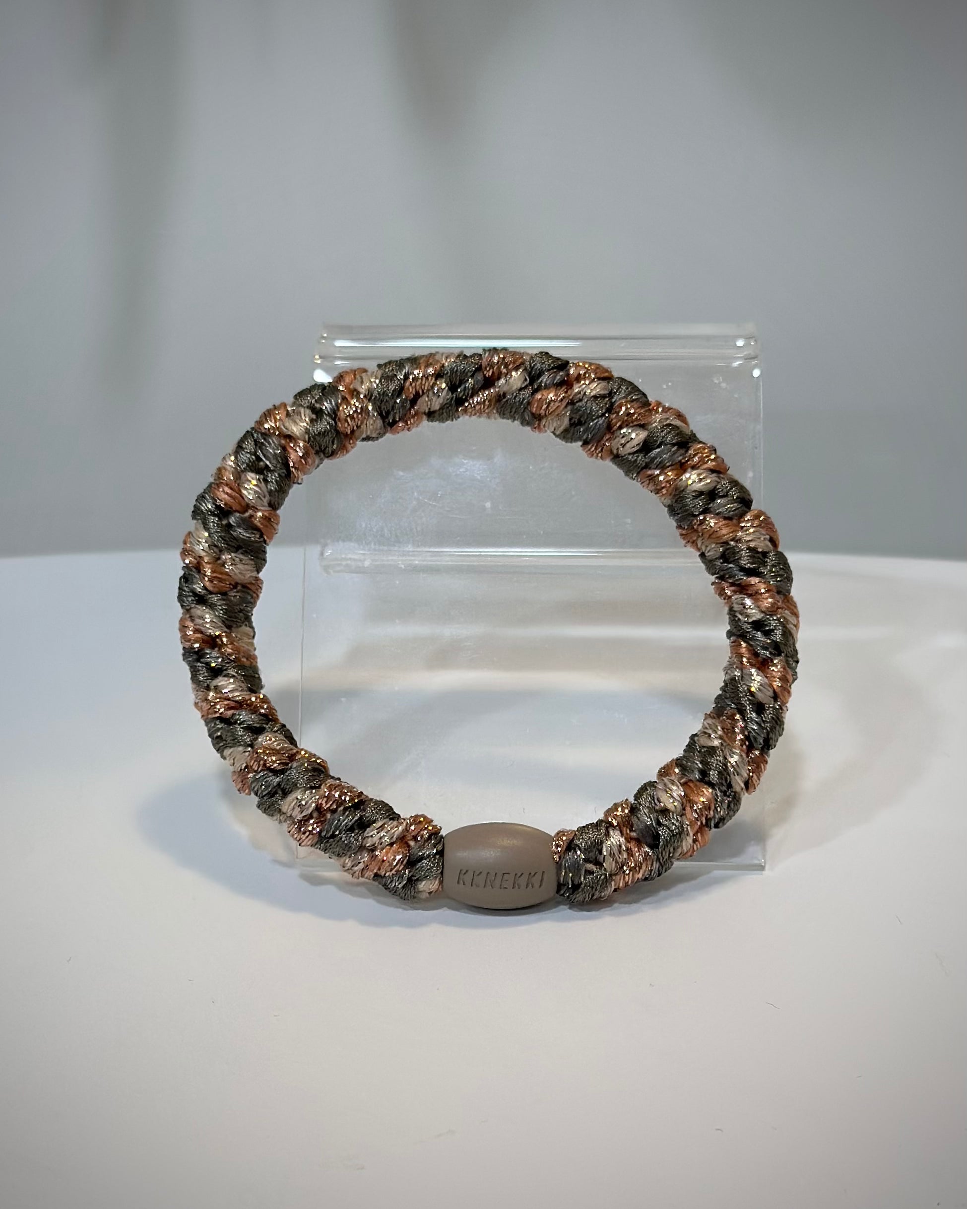 élastiques cheveux Kknekki kaki rose gold posés sur table en bois clair