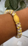 Bracelet Kknekki jaune et doré au poignet