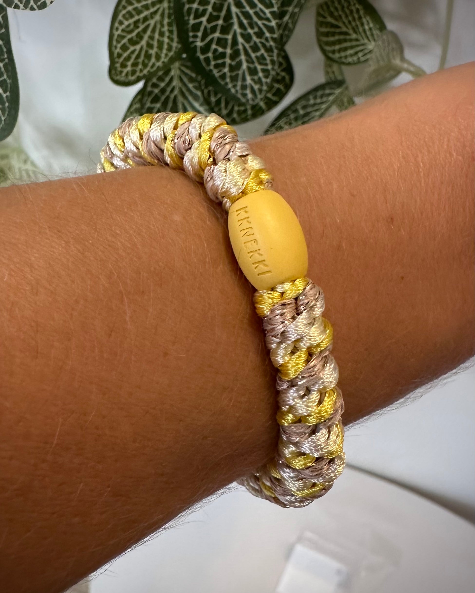 Bracelet Kknekki jaune et doré au poignet