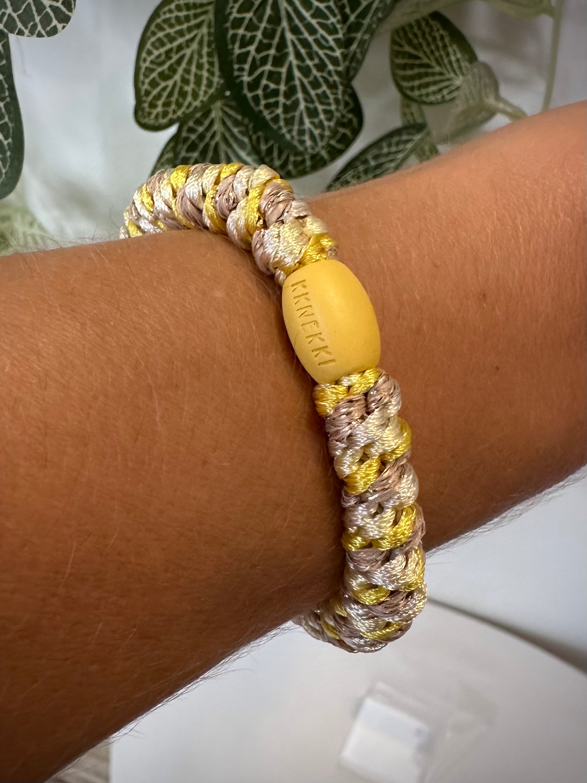 Bracelet Kknekki jaune et doré au poignet