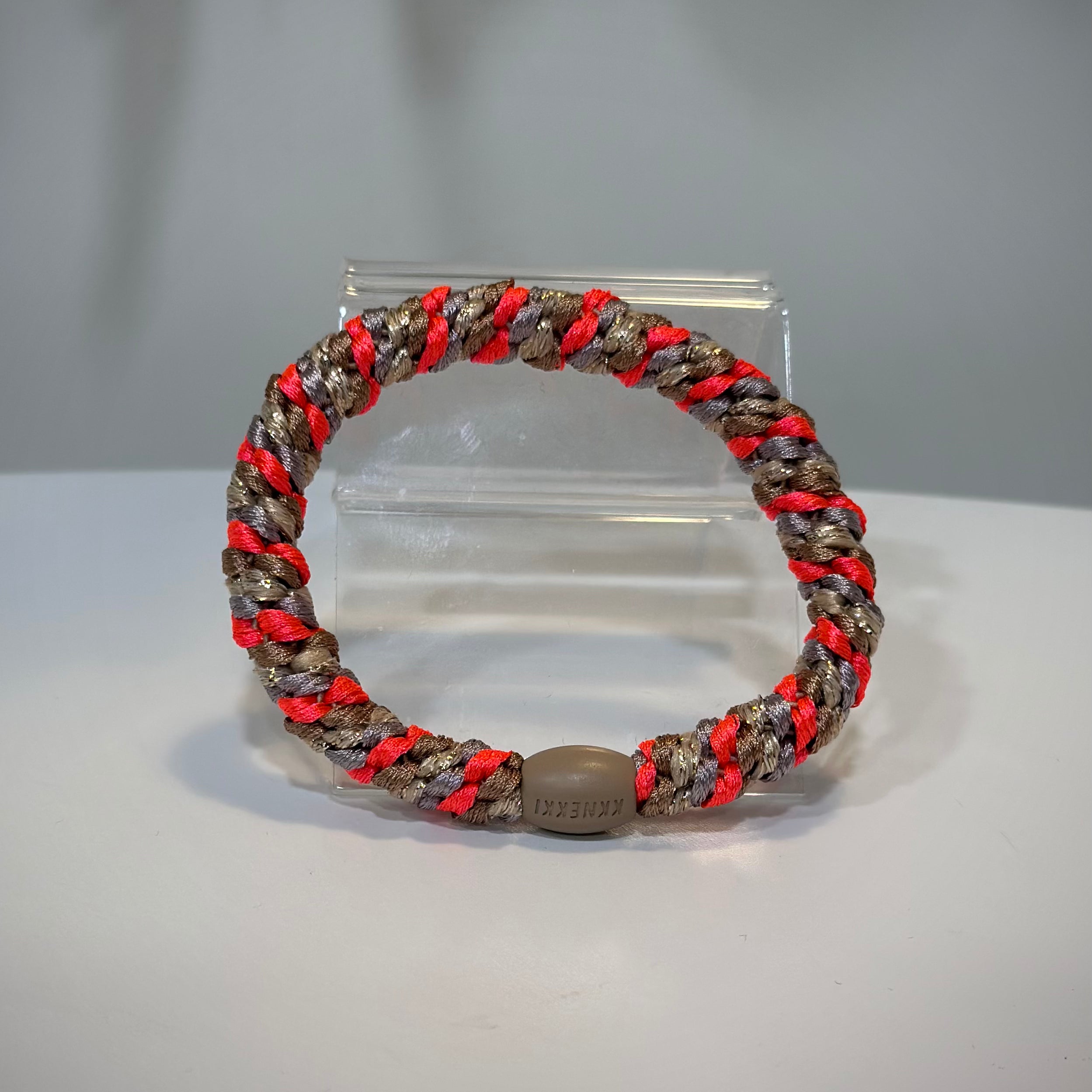 élastique pailleté rose fluo posé sur une table claire