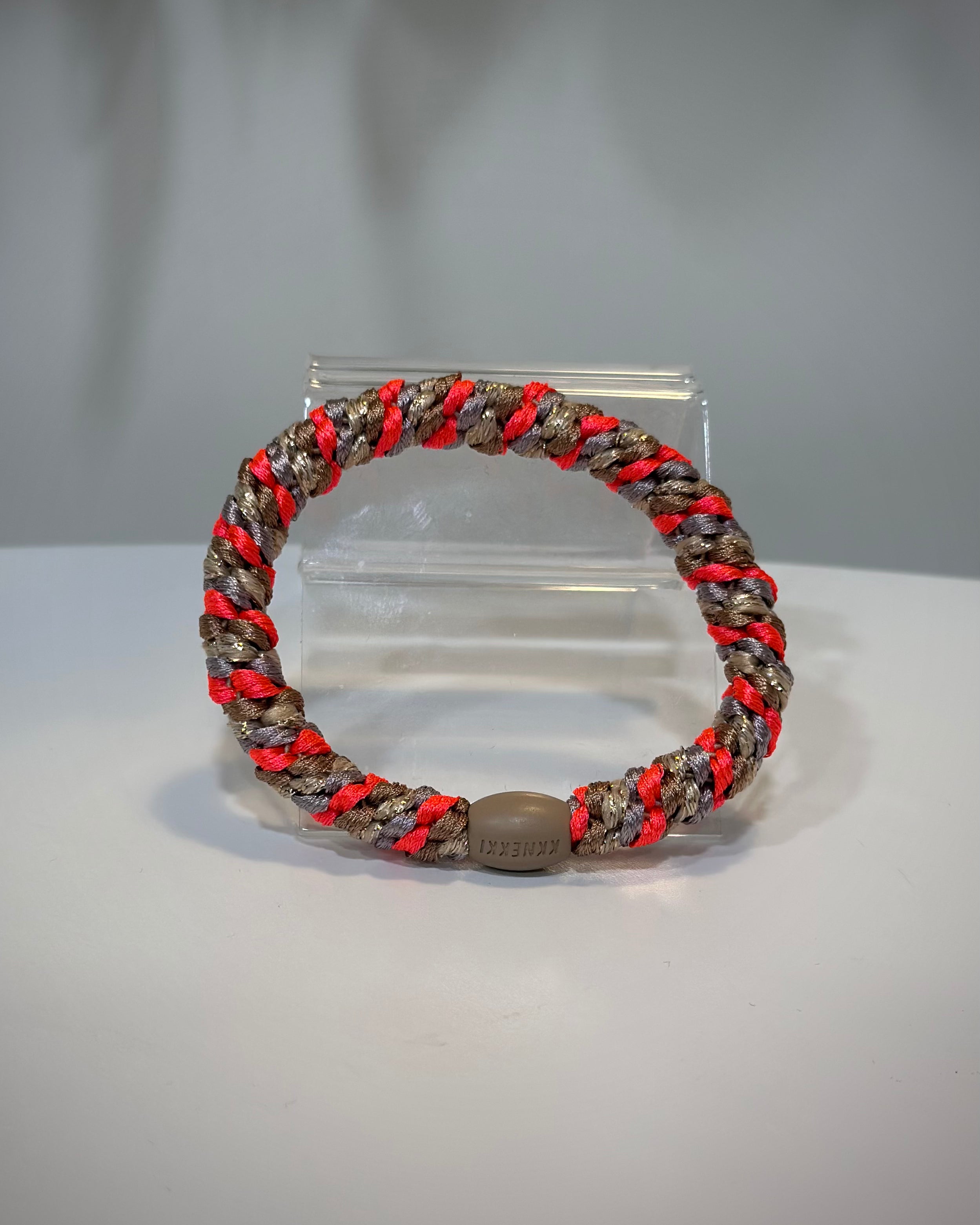 élastique pailleté rose fluo posé sur une table claire